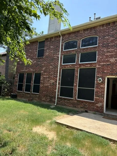 Brick exterior with varied window designs and a ground-level patio