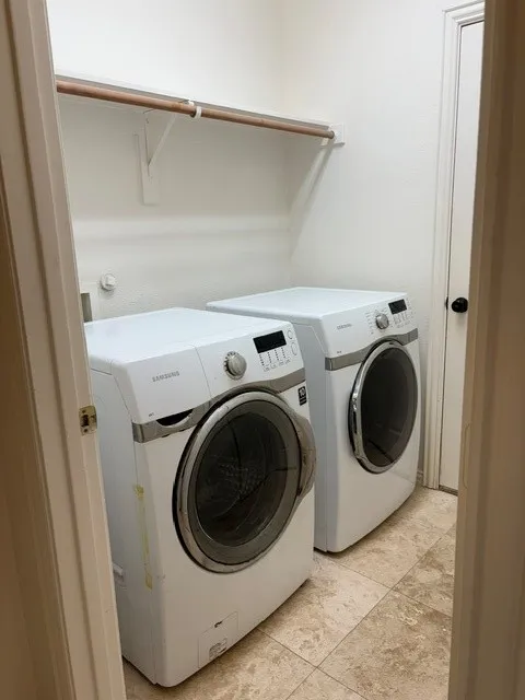 Dedicated utility area with tile flooring, a built-in hanging rod, and light-toned wall paint