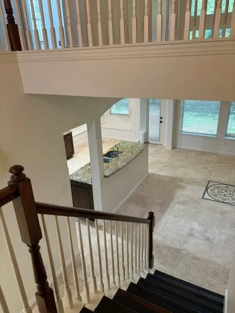 Two-story foyer with dark wood-finish stairs and white balusters