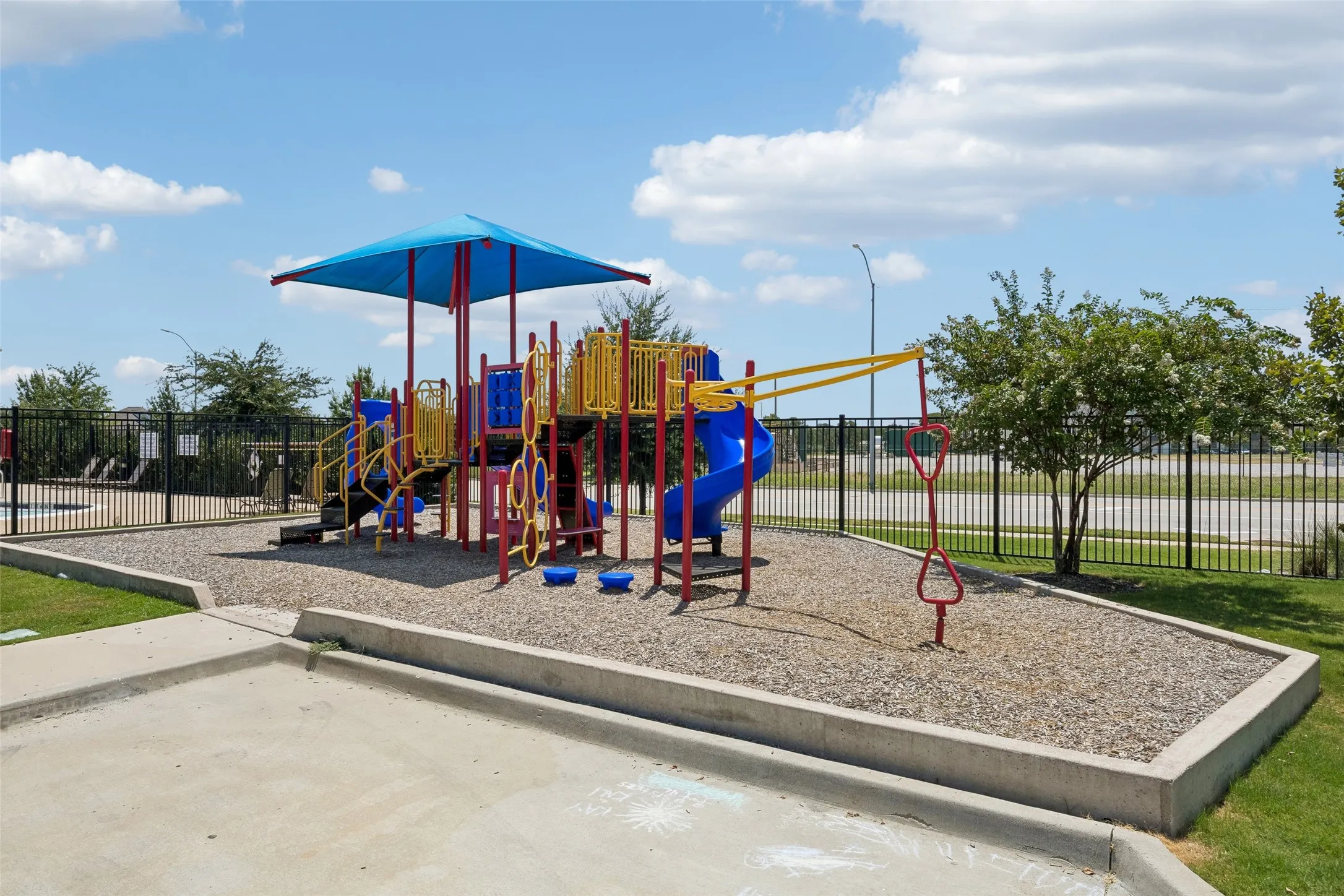 Playground area featuring a slide, climbing structures, and protective surfacing