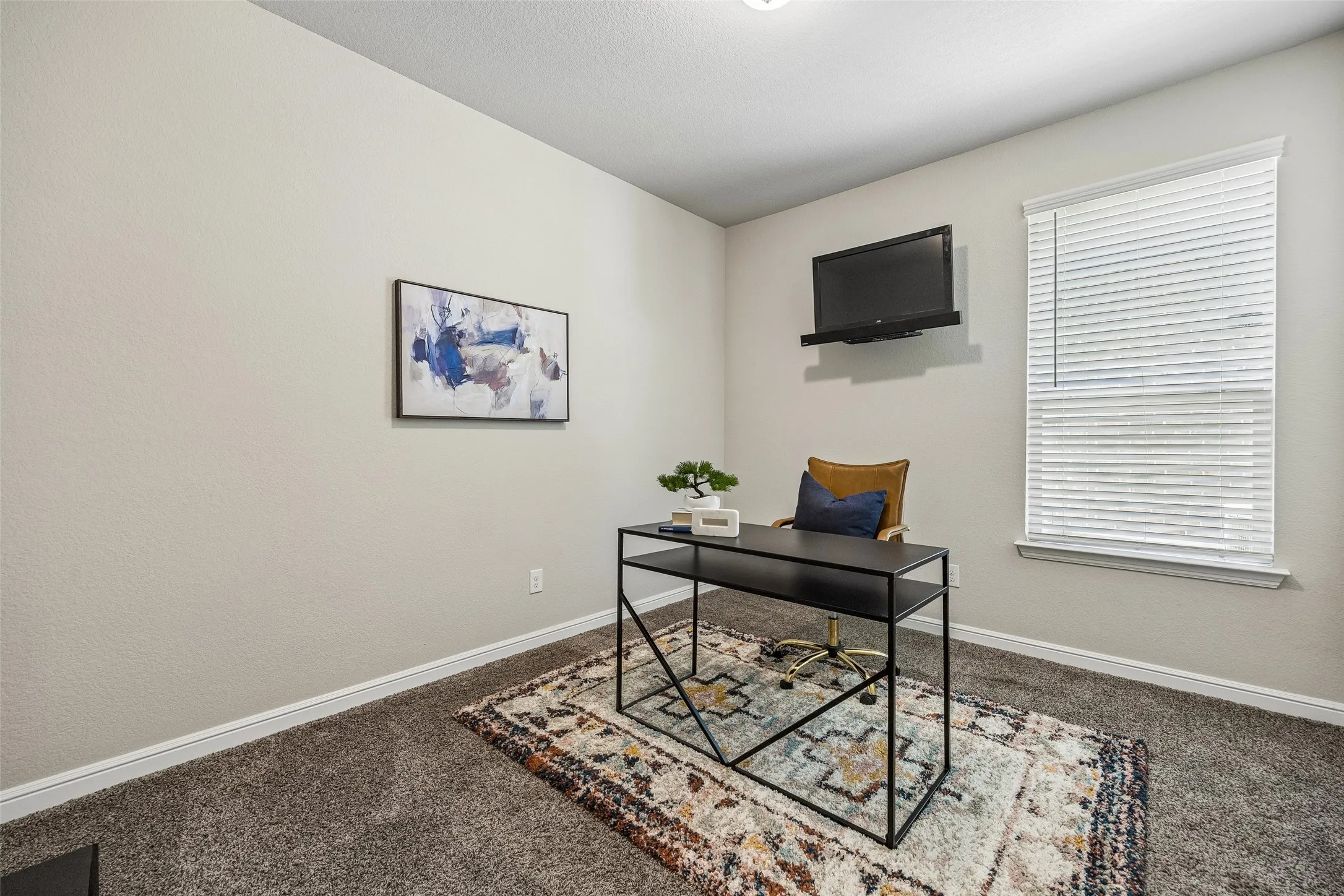 Dedicated office space with neutral tone wall paint, window with blinds, and wall-mounted shelving