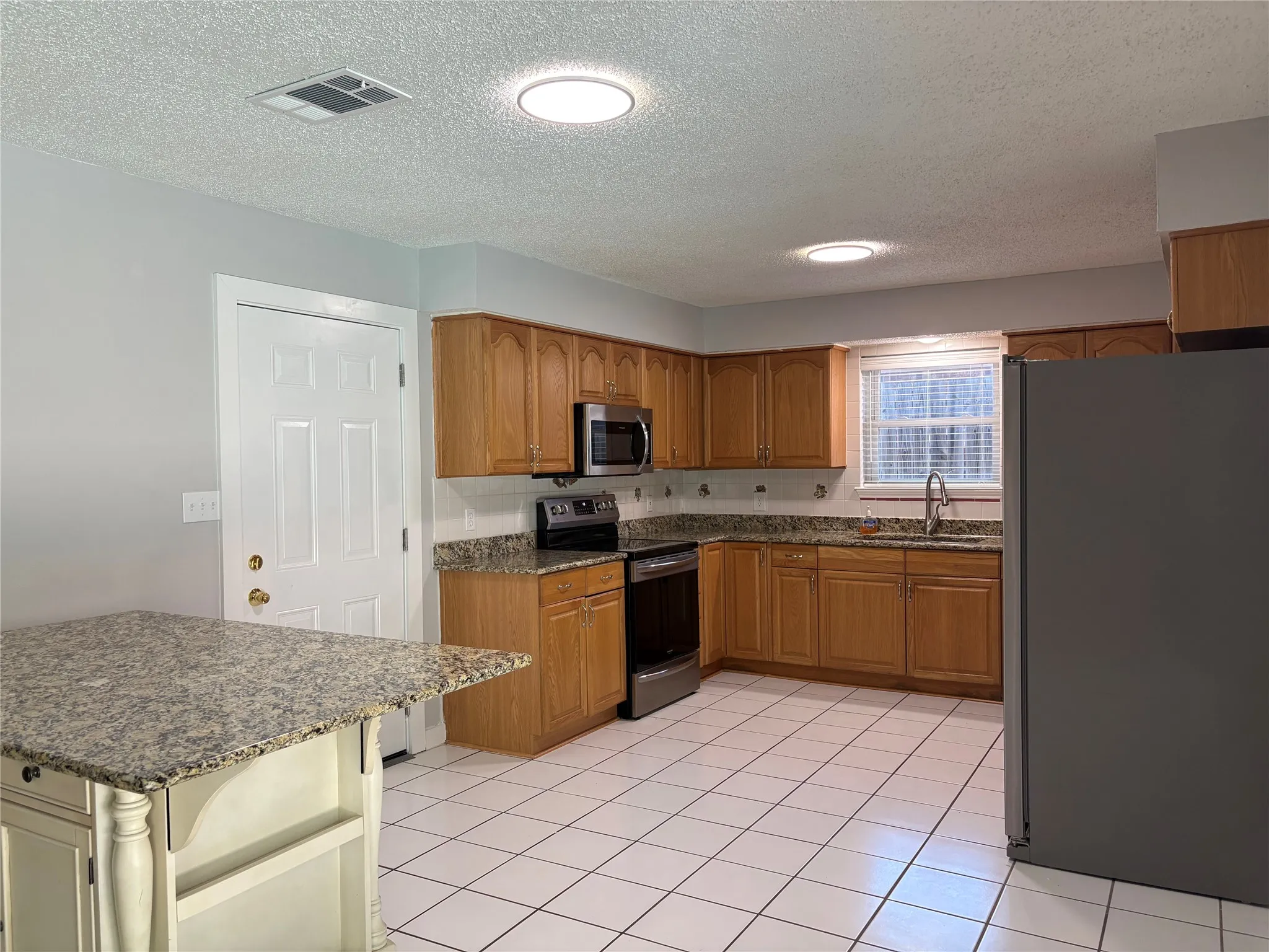 The spacious kitchen features granite countertops and stainless steel appliances.