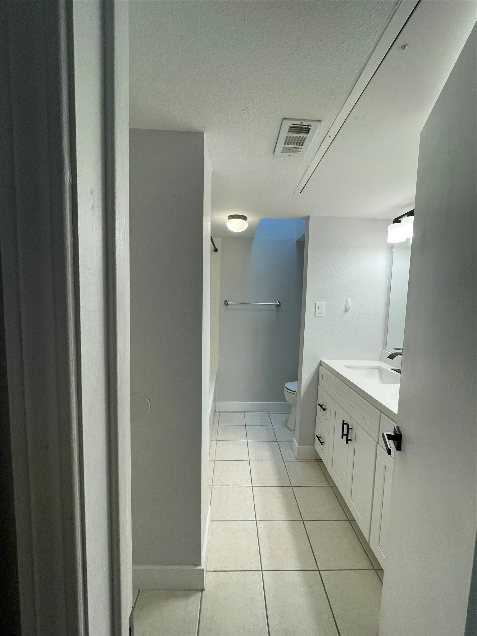 White tile flooring extending through the space