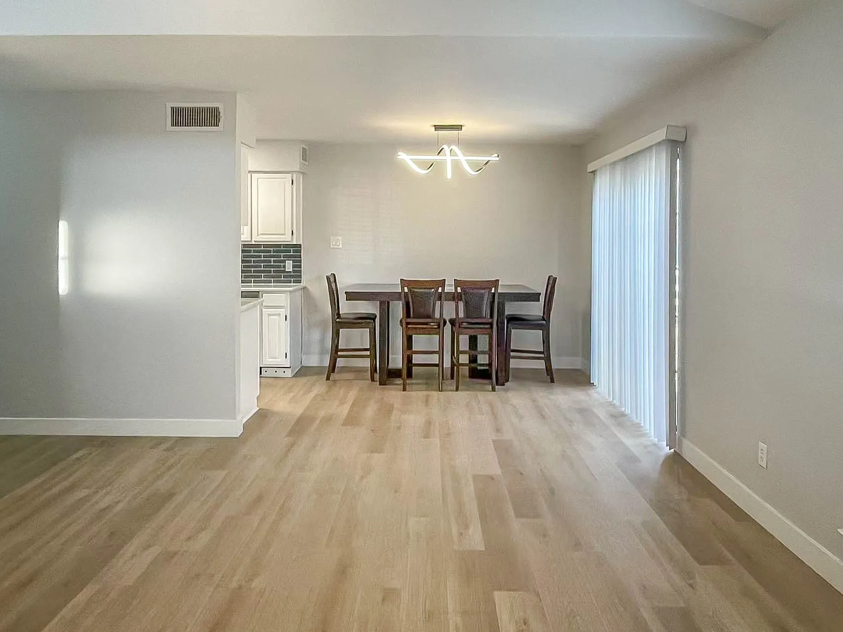 Wood-finish flooring throughout, paired with light neutral wall tones