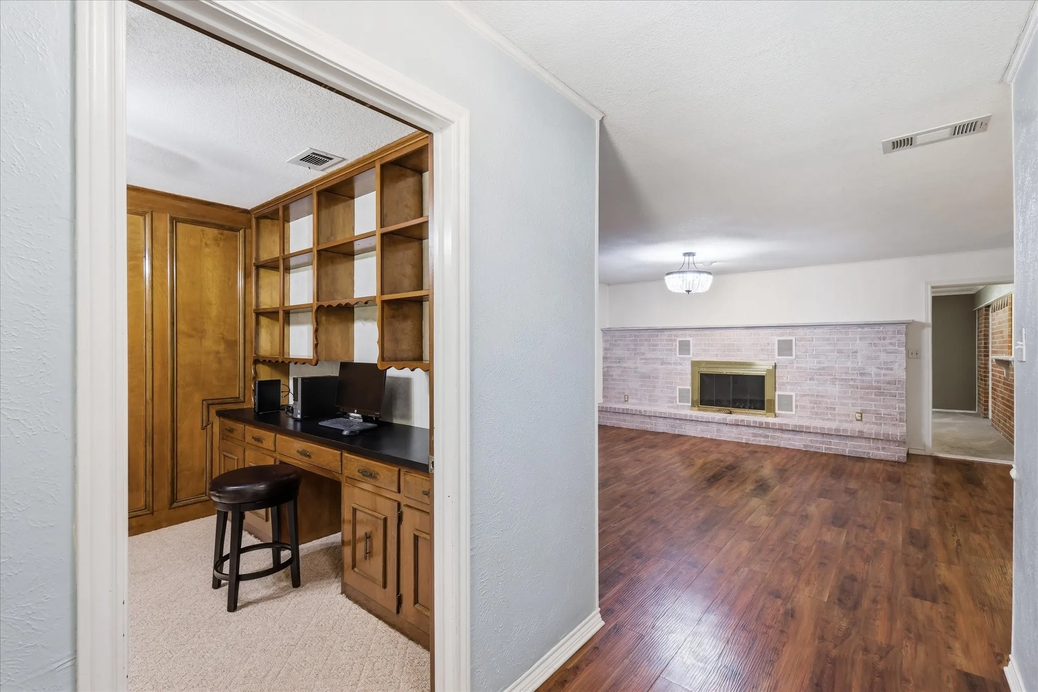 View of office with built-ins and living area from from entry.