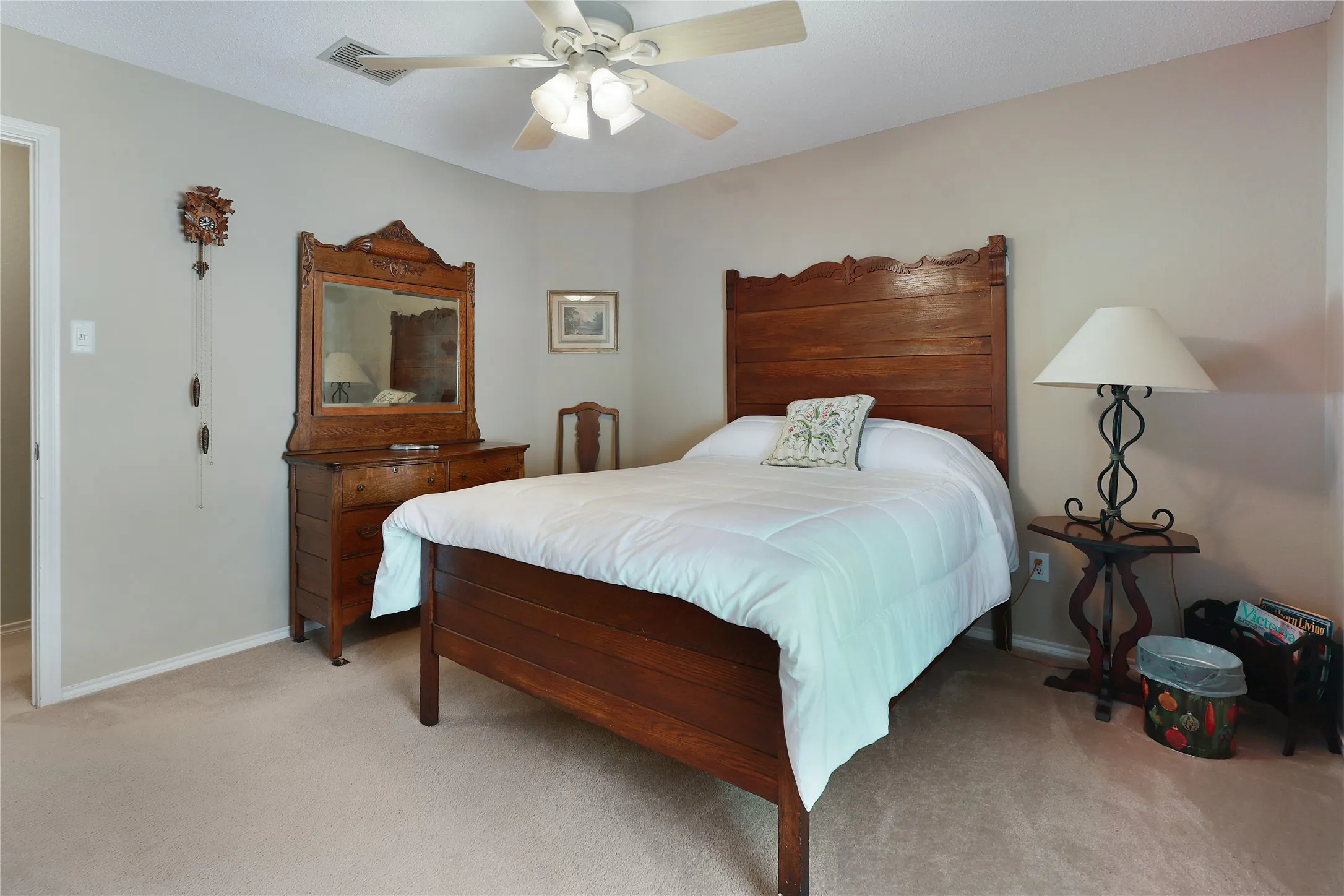 Neutral wall paint, ceiling fan with light fixture, and carpeted flooring