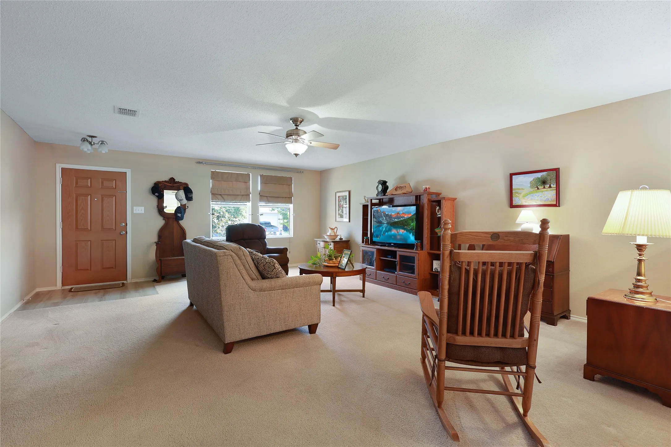 Light-toned walls complement the carpeted flooring