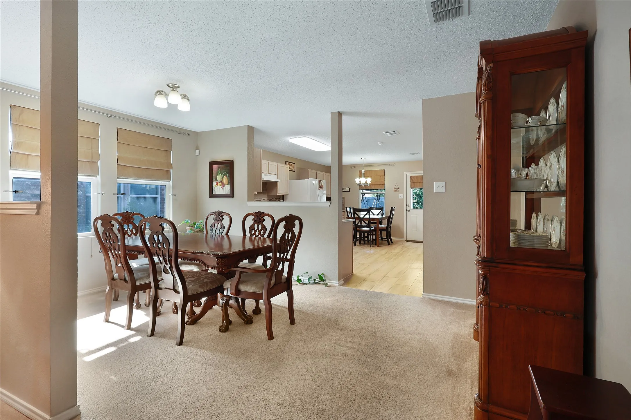 Carpeted dining area with neutral wall tones and multiple windows