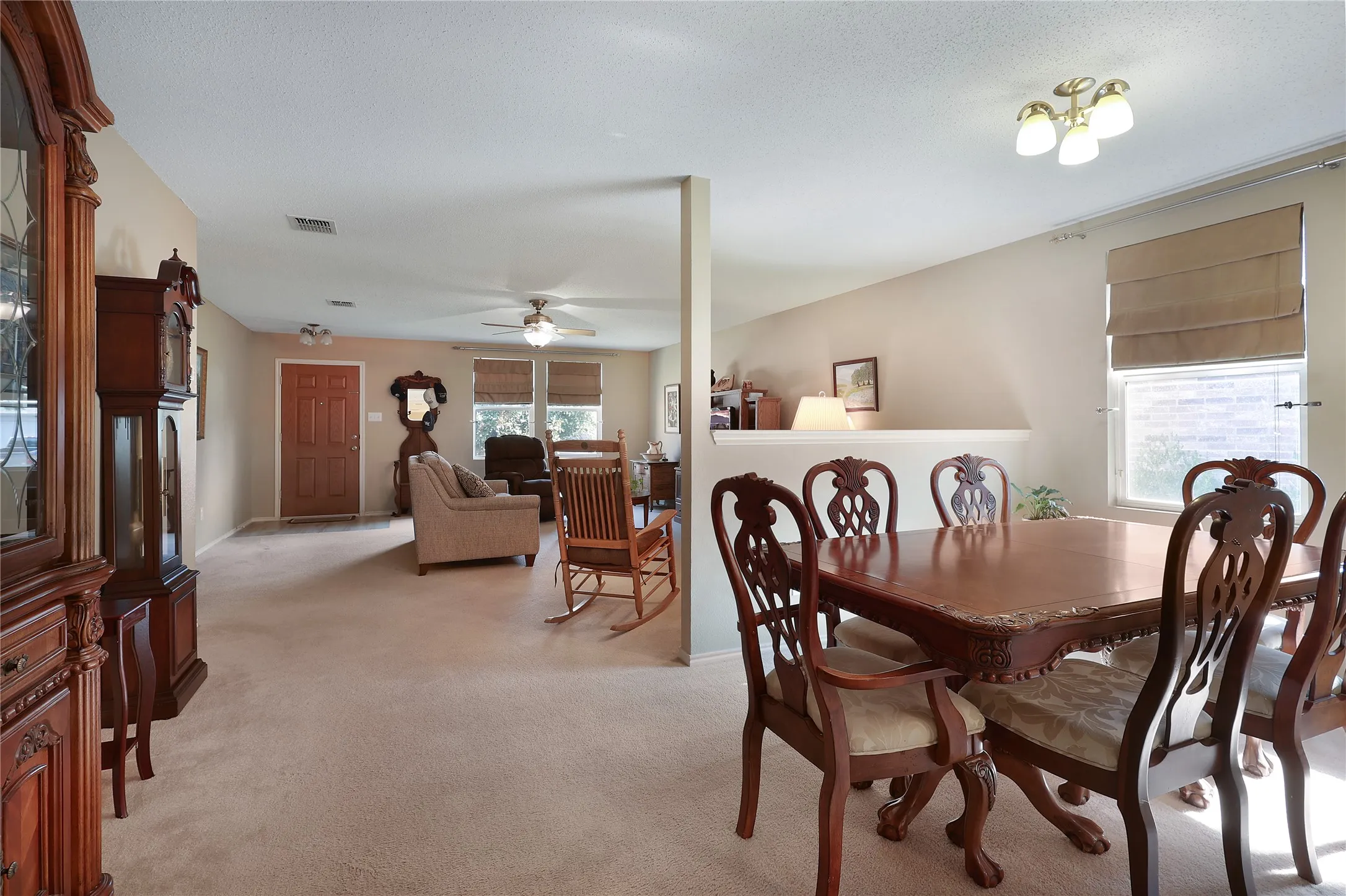 Open-concept living and dining areas with ceiling fan, recessed lighting, and window treatments