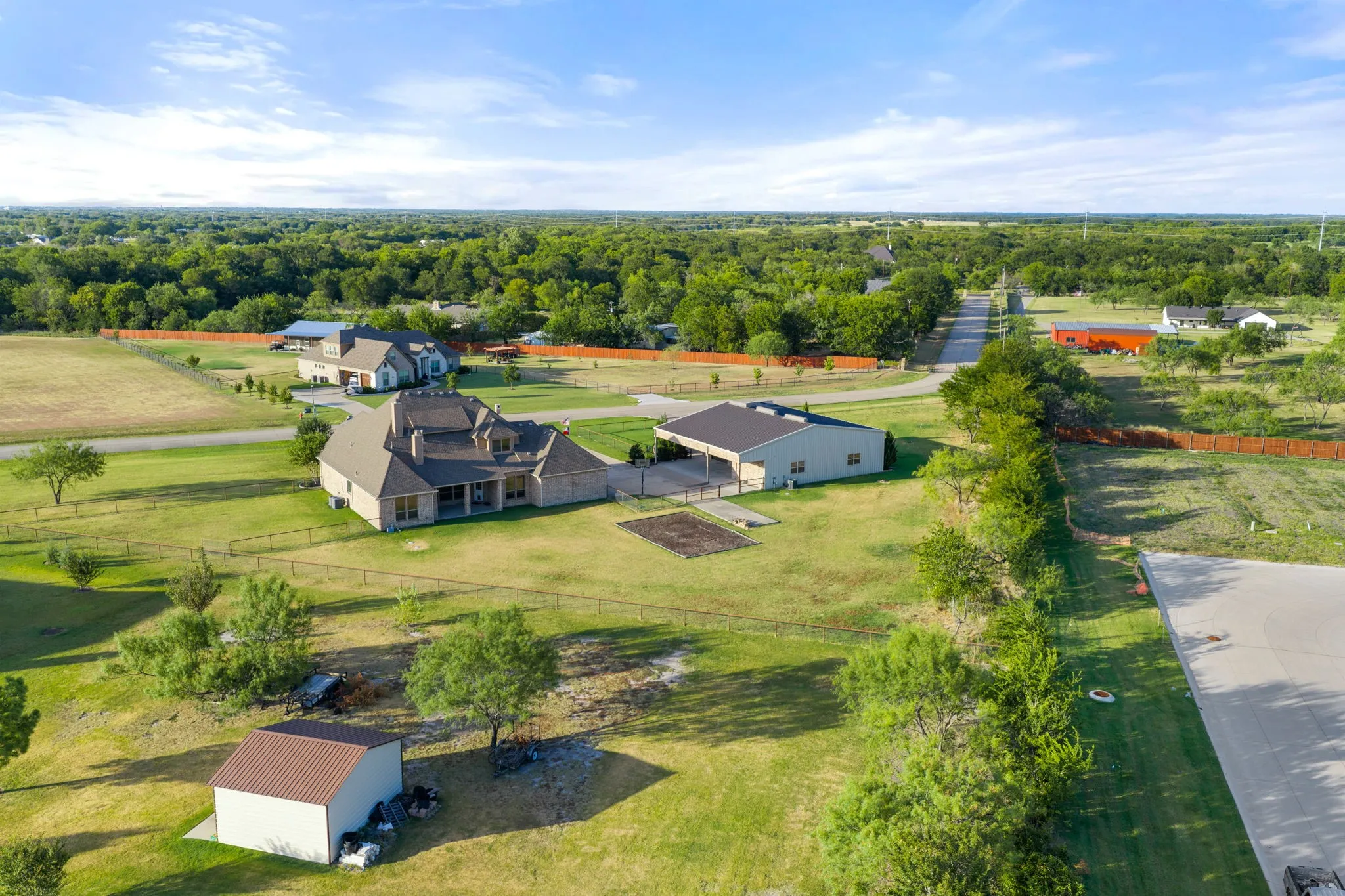 Expansive property with a brick exterior residence, detached garage structure, and a secondary outbuilding