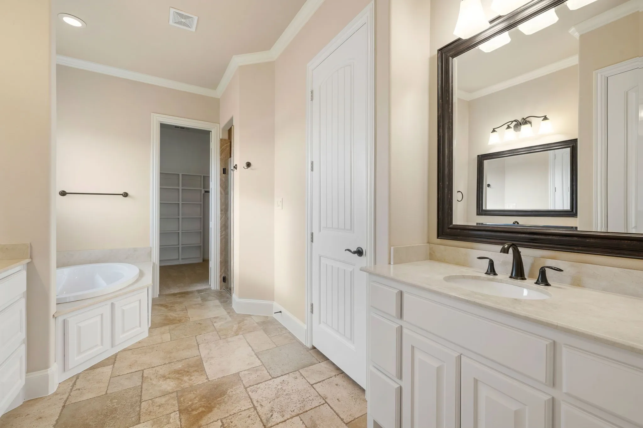 Double vanity with undermount sinks, stone countertops, and matte black fixtures
