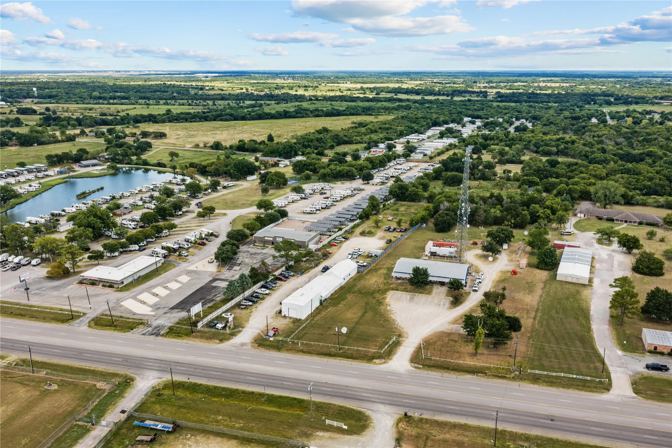 Expansive property featuring a large body of water, extensive paved areas, multiple structures, and a prominent communications tower