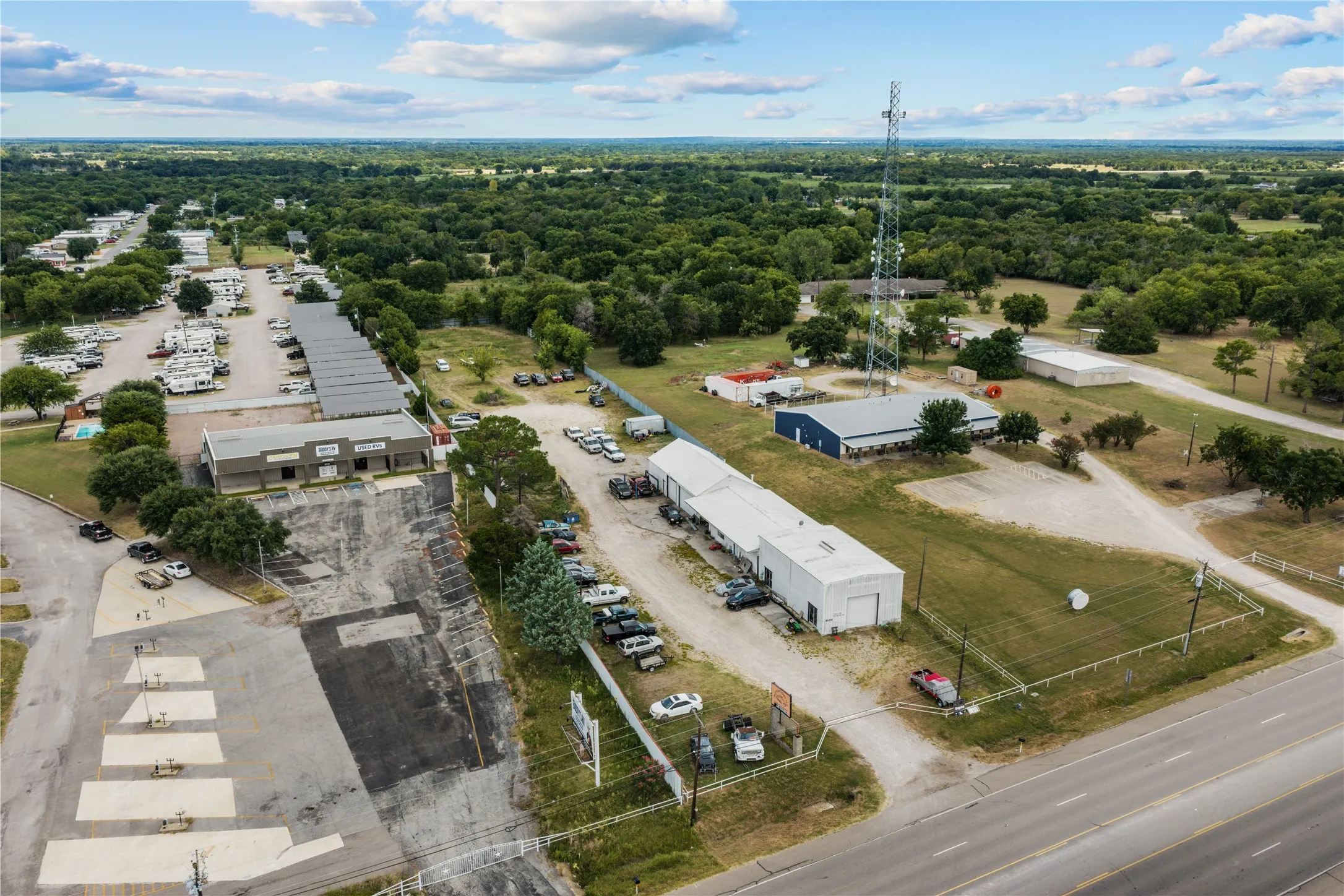 Multiple commercial buildings with paved and gravel parking areas