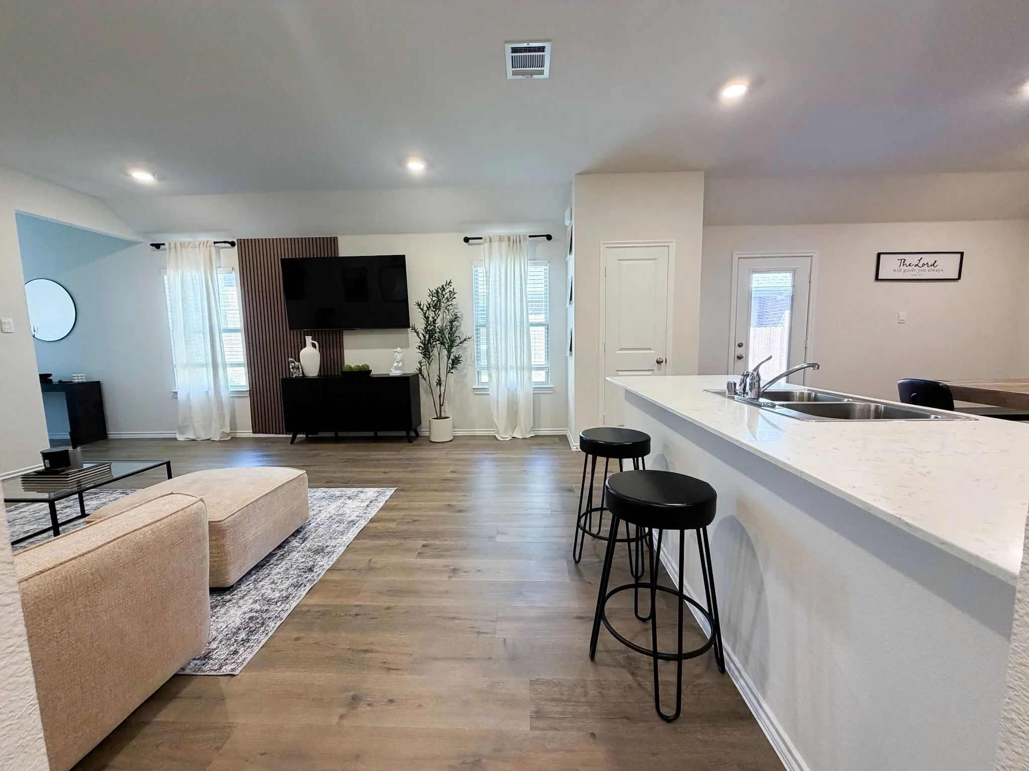 Open concept living area featuring wood-finish flooring and recessed lighting
