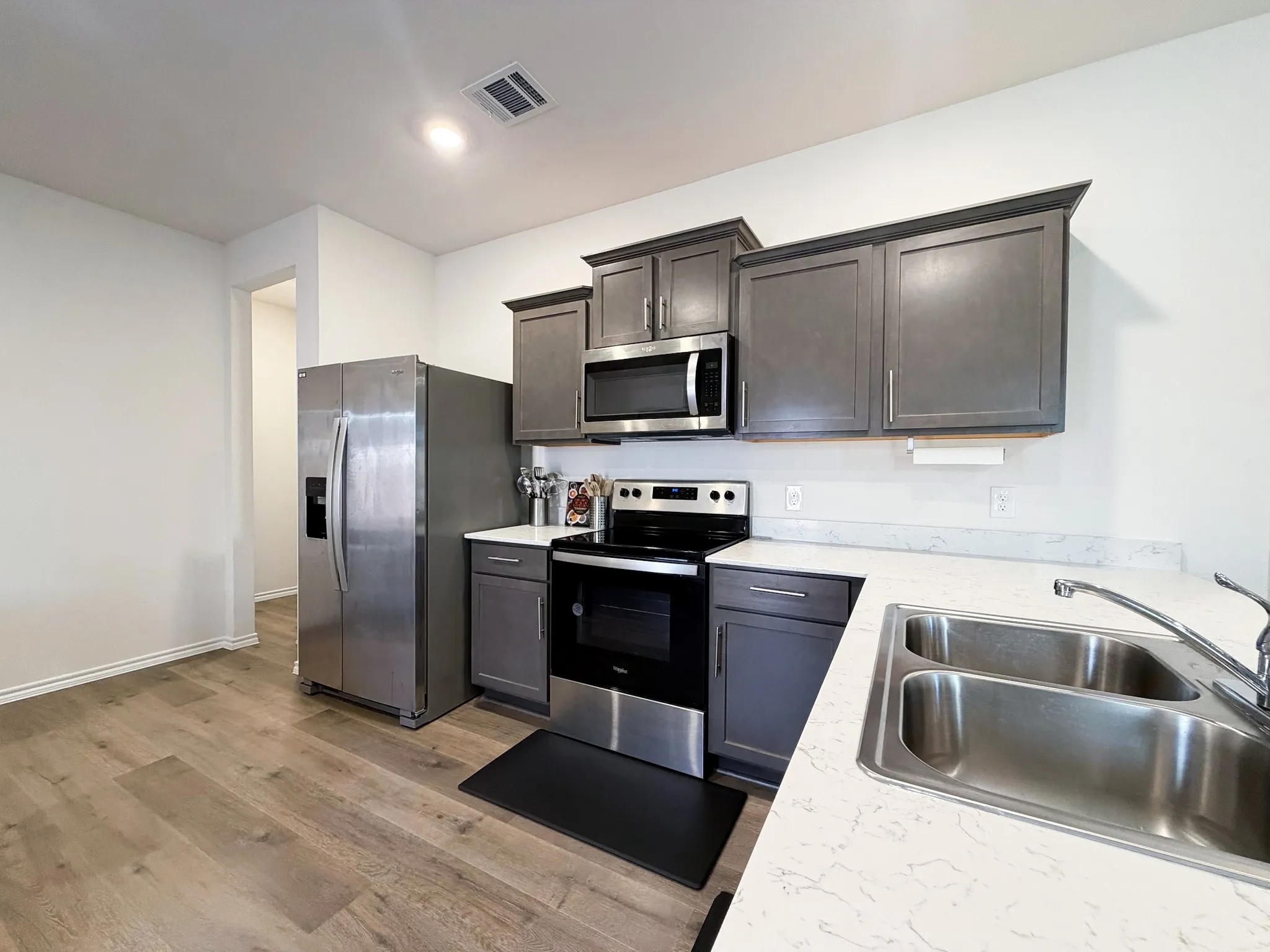 Kitchen featuring wood-finish flooring, white countertops, stainless steel appliances, and grey​​‌​​​​‌​​‌‌​‌‌​​​‌‌​‌​‌​‌​​​‌​​ cabinetry