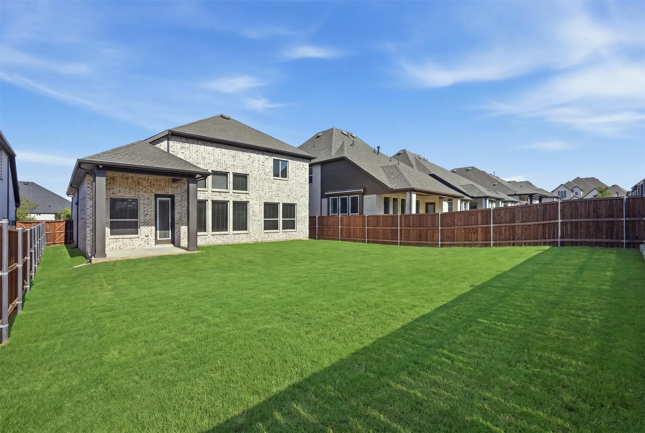 Expansive green lawn enclosed by a full privacy fence, offering a spacious and private outdoor setting ideal for recreation, relaxation, and entertaining