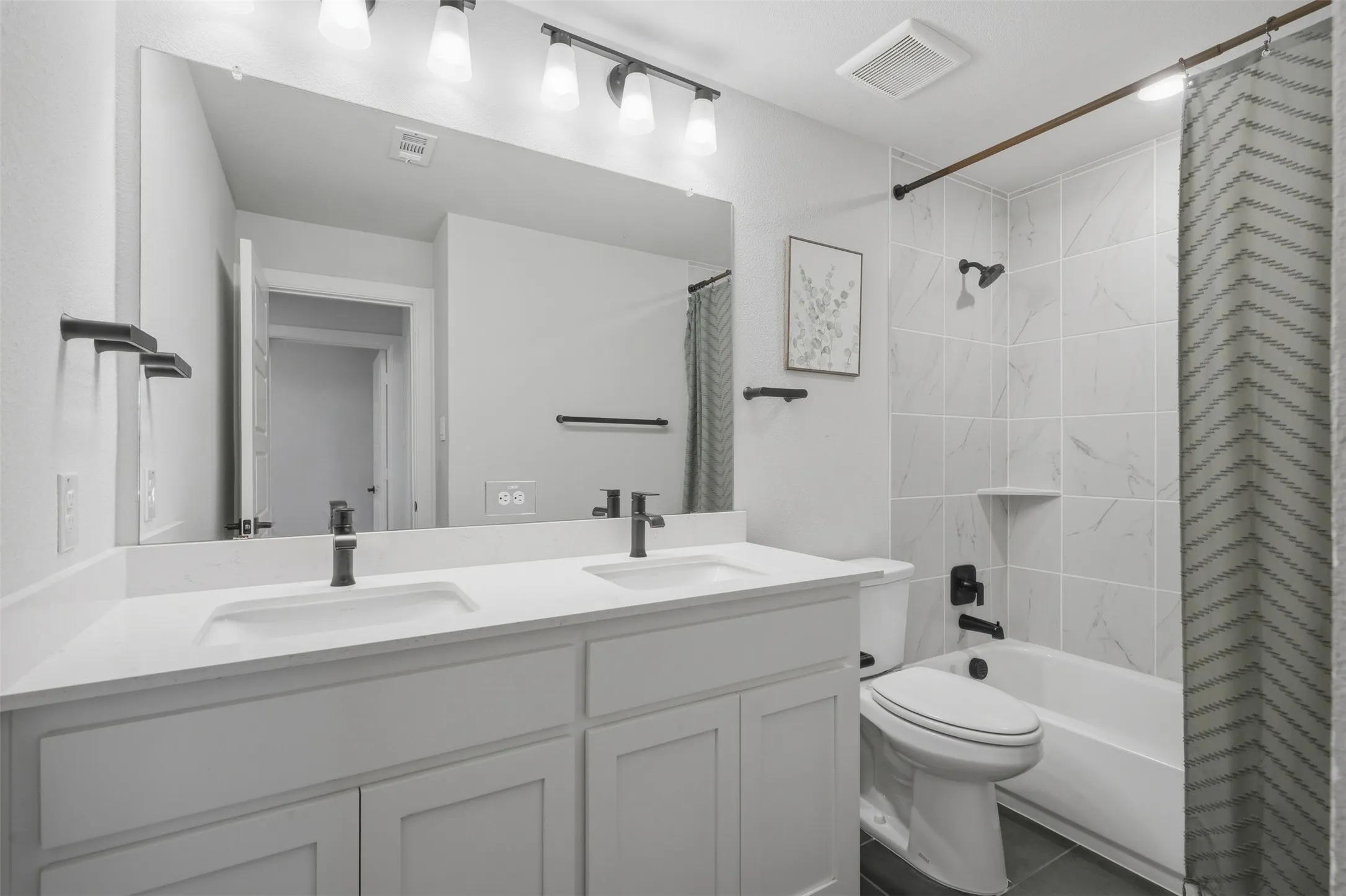 Stylish dual vanity featuring undermount sinks, crisp white countertops, and ample counter space, combining everyday functionality with a clean, modern aesthetic