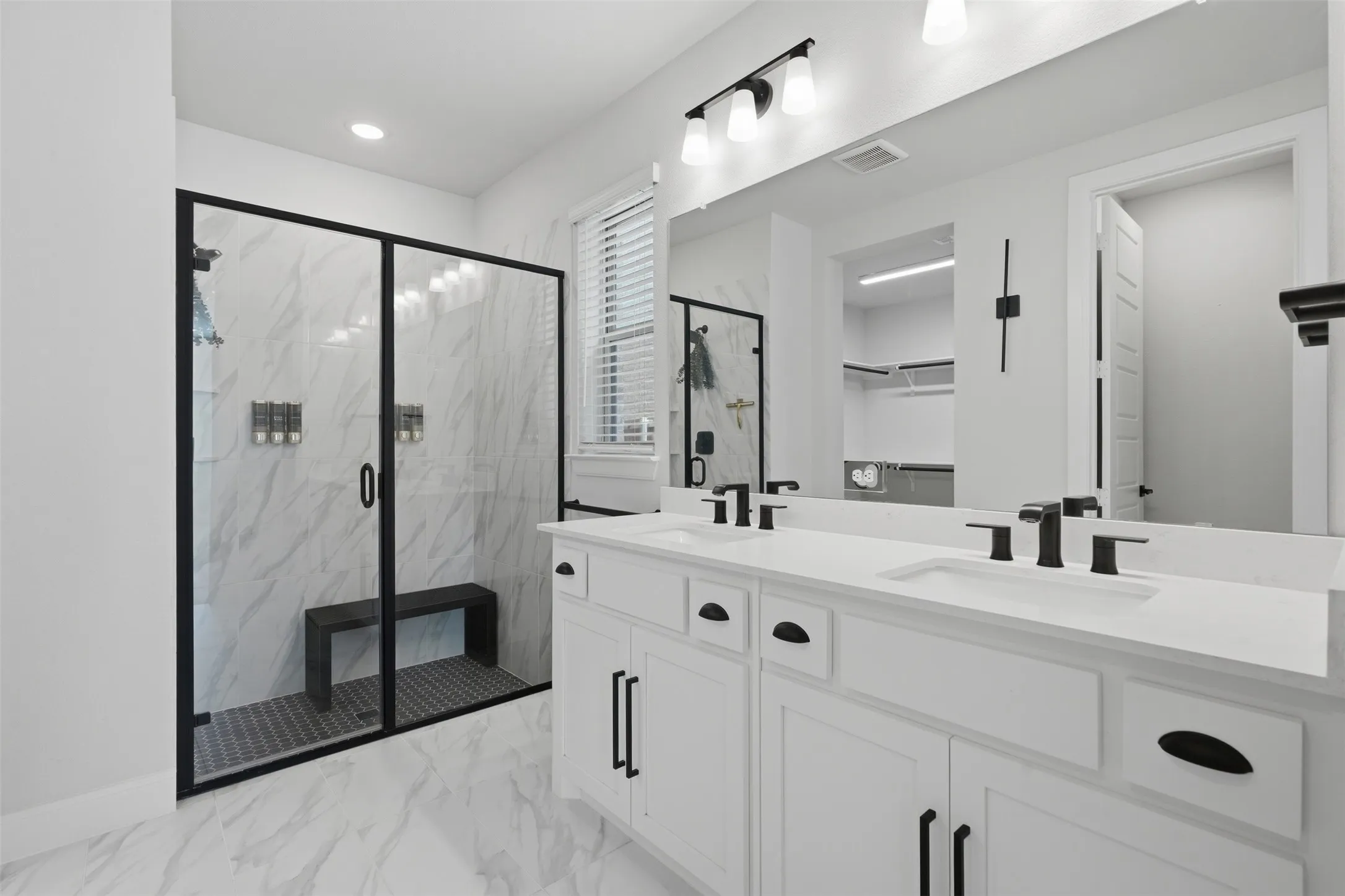 Modern dual vanity featuring crisp white cabinetry, matte black hardware, and an expansive mirror, creating a bright, polished space with ample everyday functionality