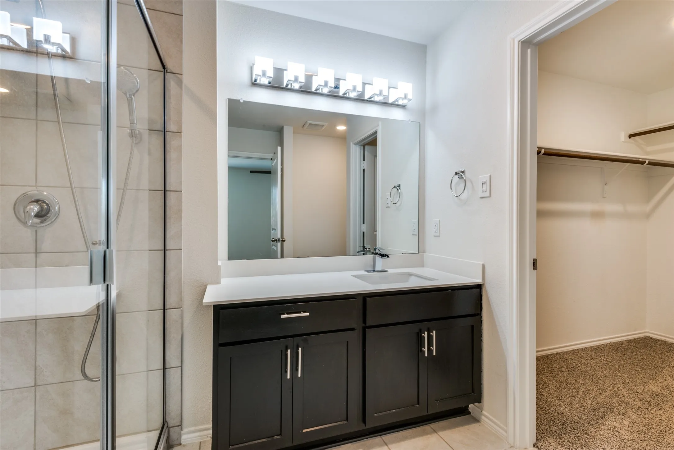 Walk-in shower with tile surround, glass enclosure, and integrated bench