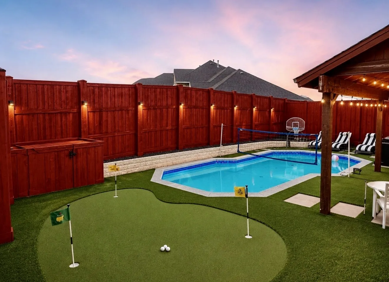 Backyard resort featuring a sparking pool, hot tub, professionally installed turf, putting green and covered patio!