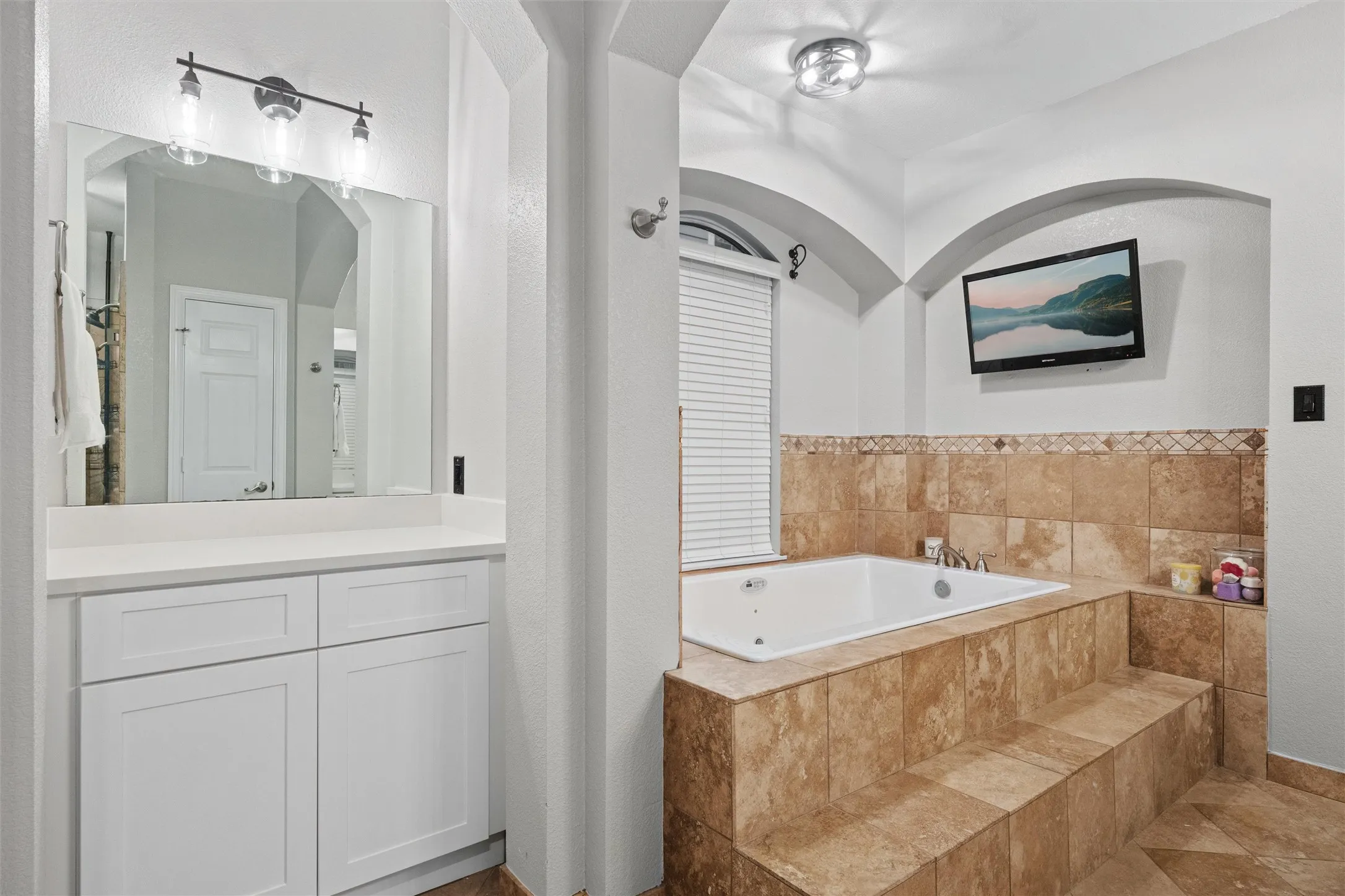 Spa-like primary bath with a jetted soaking tub and dedicated vanity area, creating a relaxing, functional retreat.