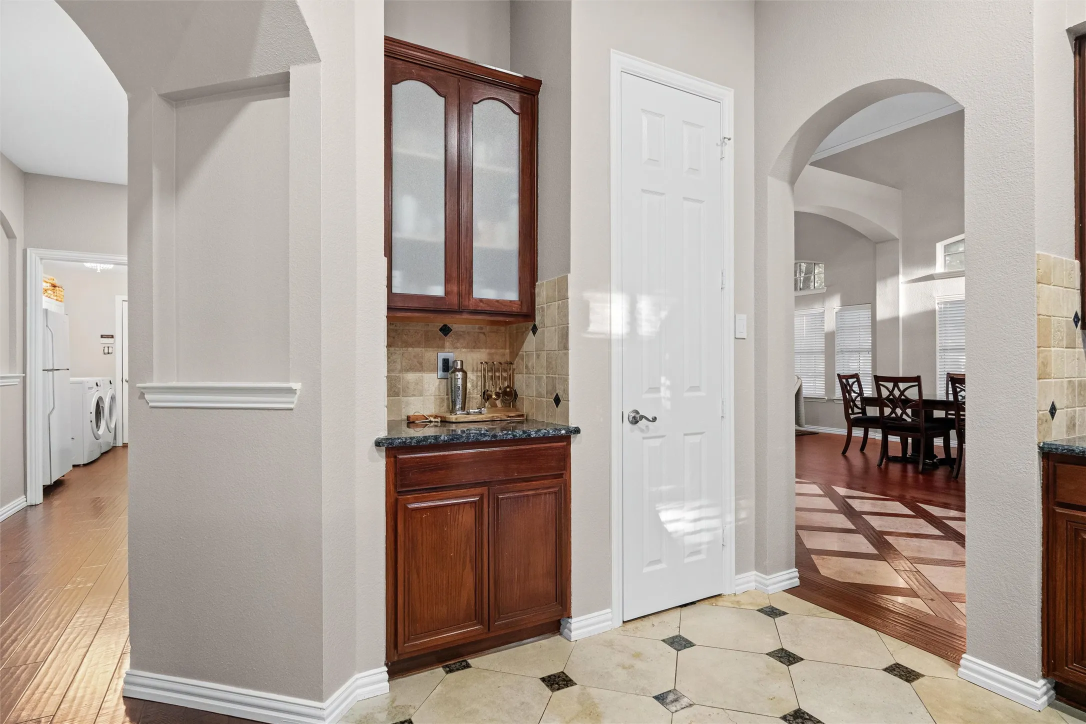 Butler's pantry with glass front cabinetry offers additional storage space.