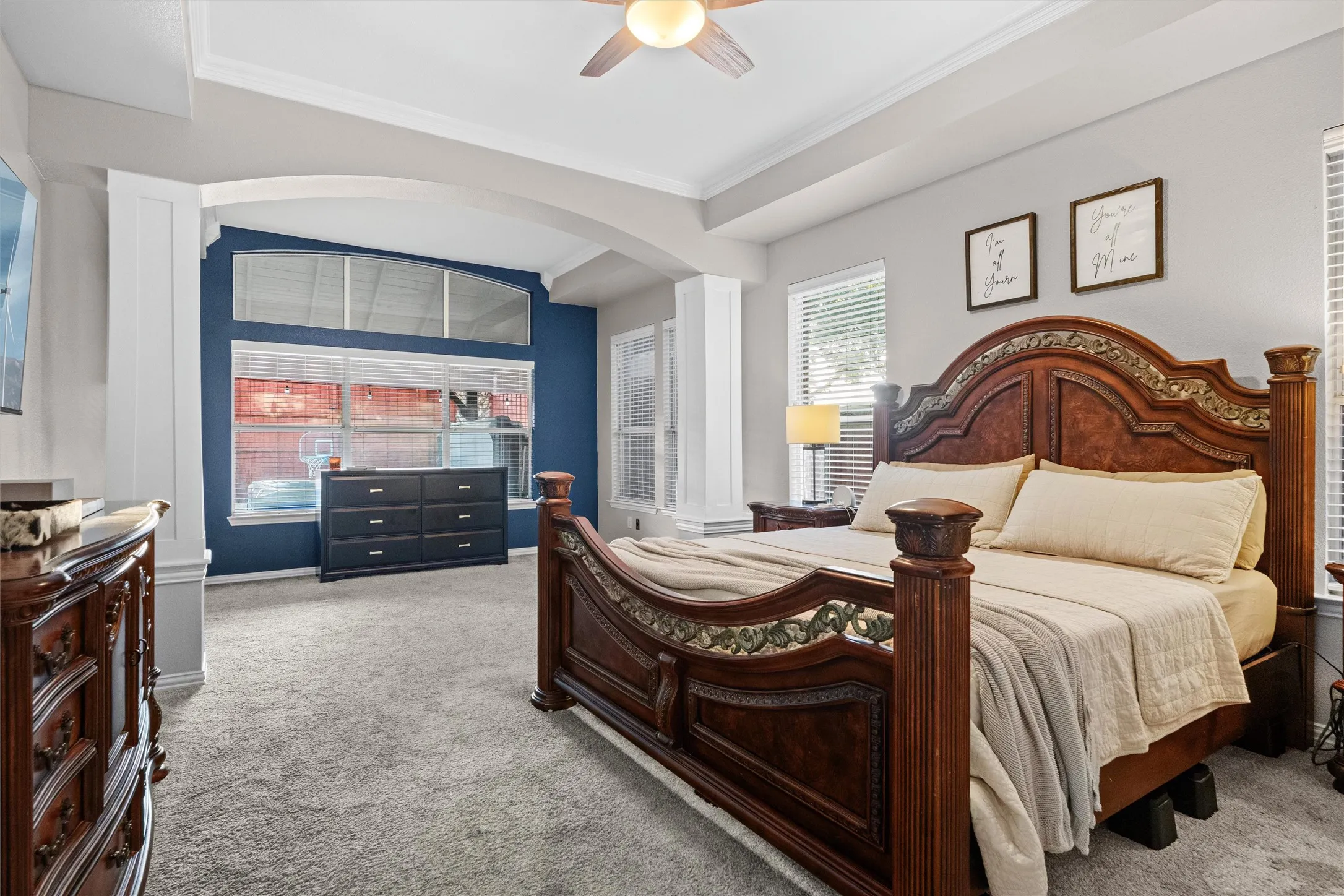 Spacious primary suite featuring a sitting area, tray ceiling, and abundant natural light.
