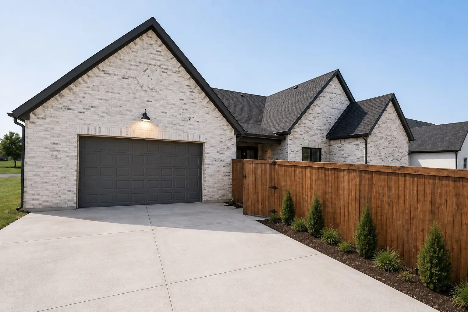 Light brick exterior with dark trim and a dark gray garage door
