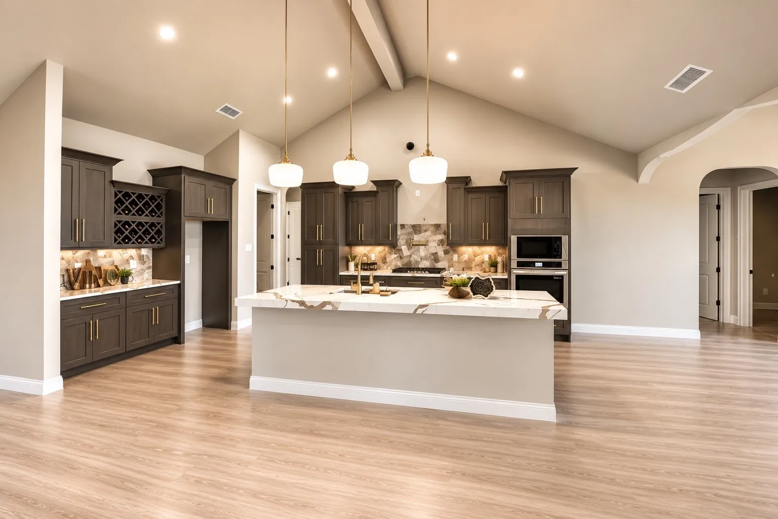 Vaulted ceiling, wood-finish flooring, central island with integrated sink, dark wood cabinetry, and recessed lighting