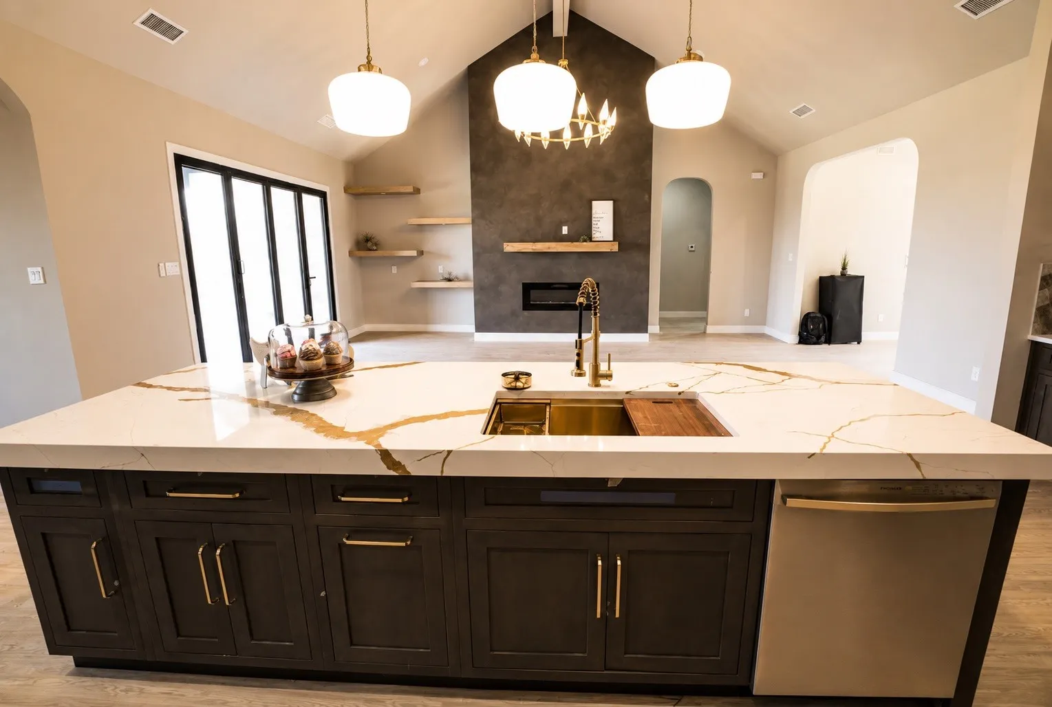 Expansive kitchen island with a gold-veined countertop, integrated sink, and dark wood-finish cabinetry