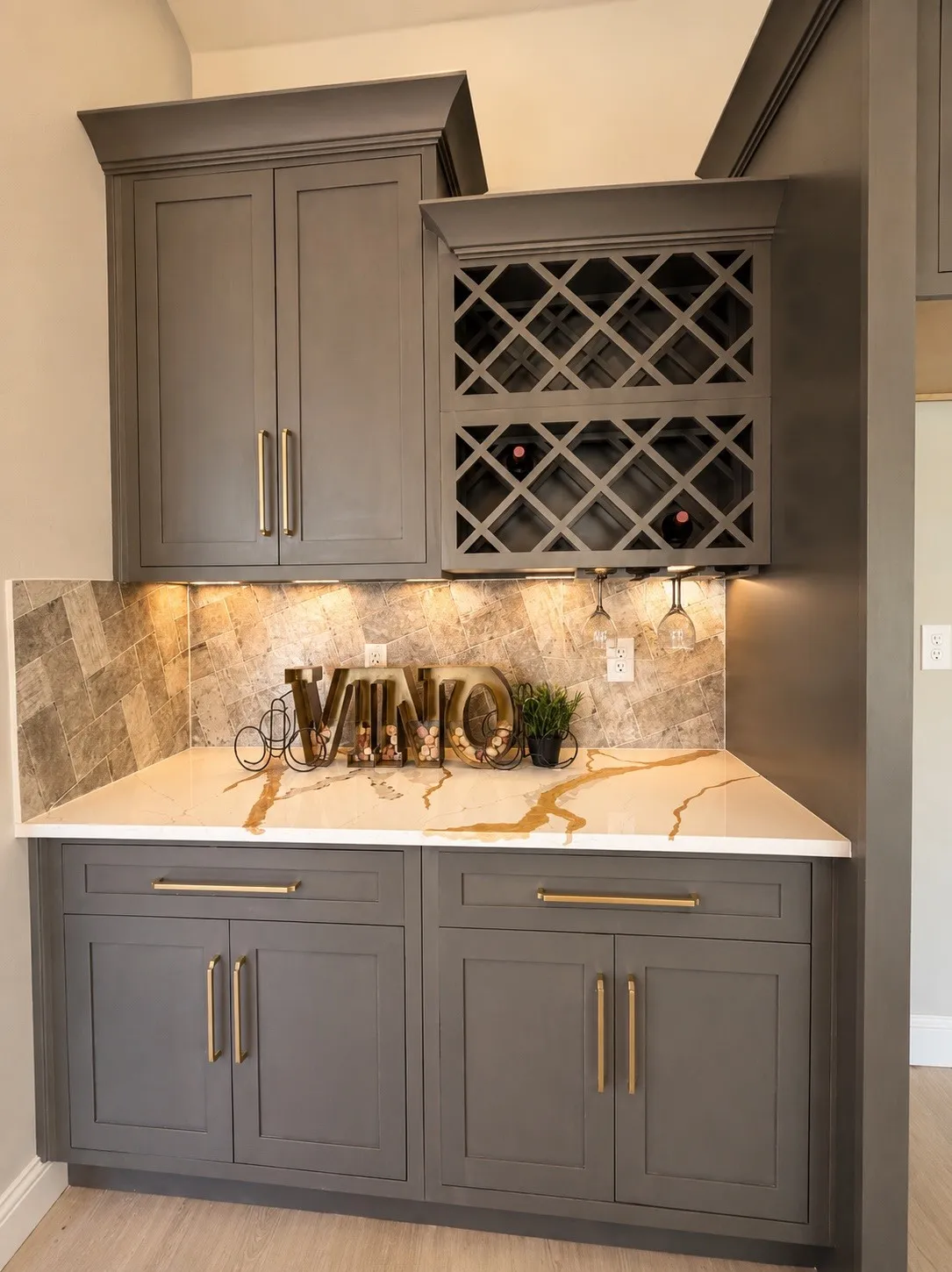 Built-in cabinetry with crown molding, integrated wine storage, under-cabinet lighting, and a patterned stone backsplash