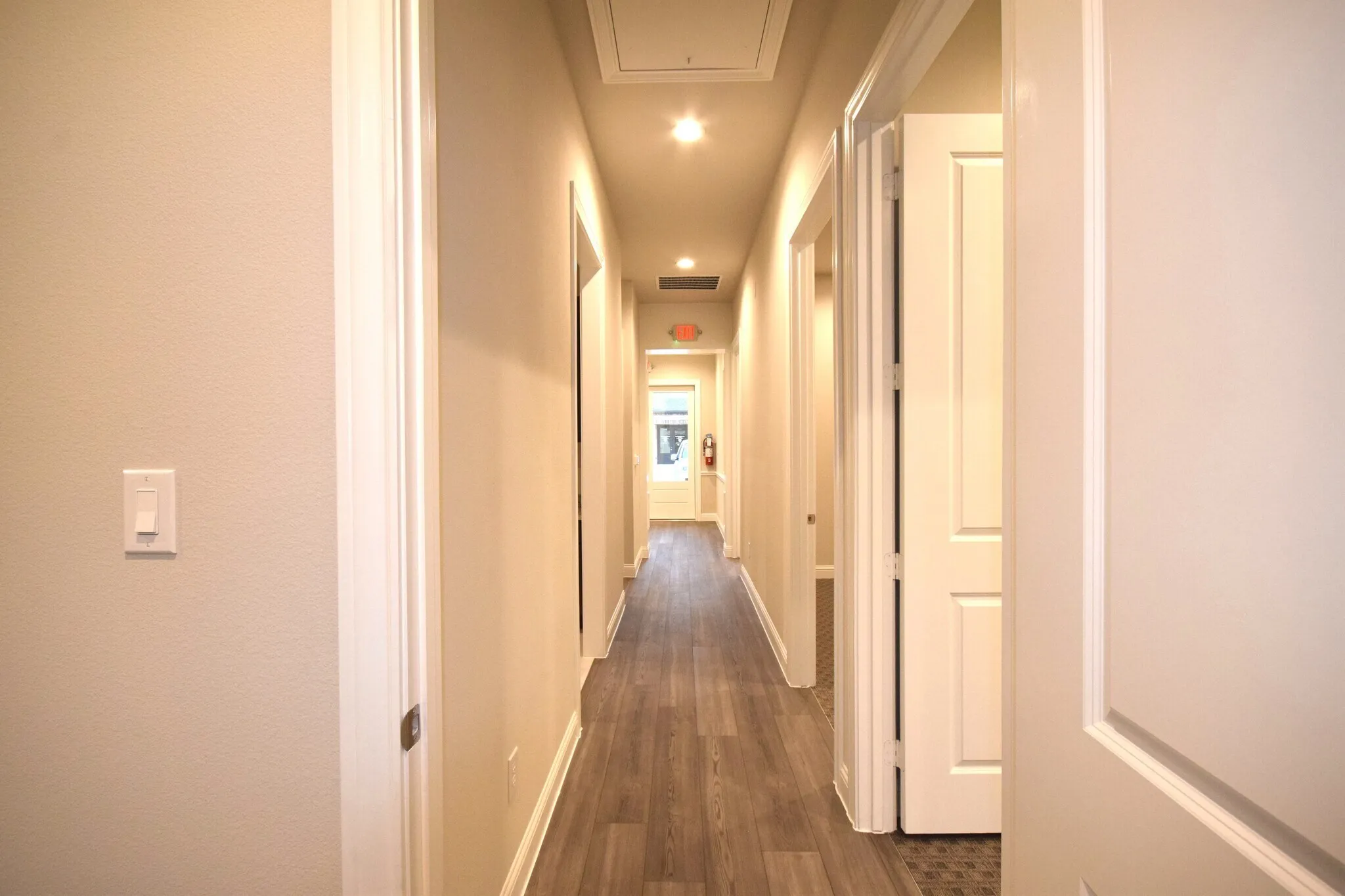 Hallway with wood-finish flooring, recessed lighting, and light-toned wall paint