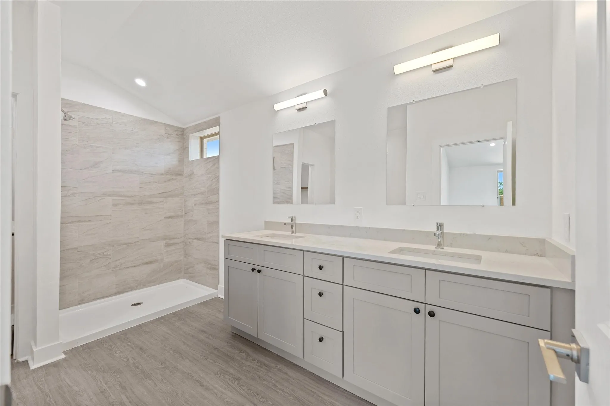 Dual vanity with light gray cabinetry and white countertops