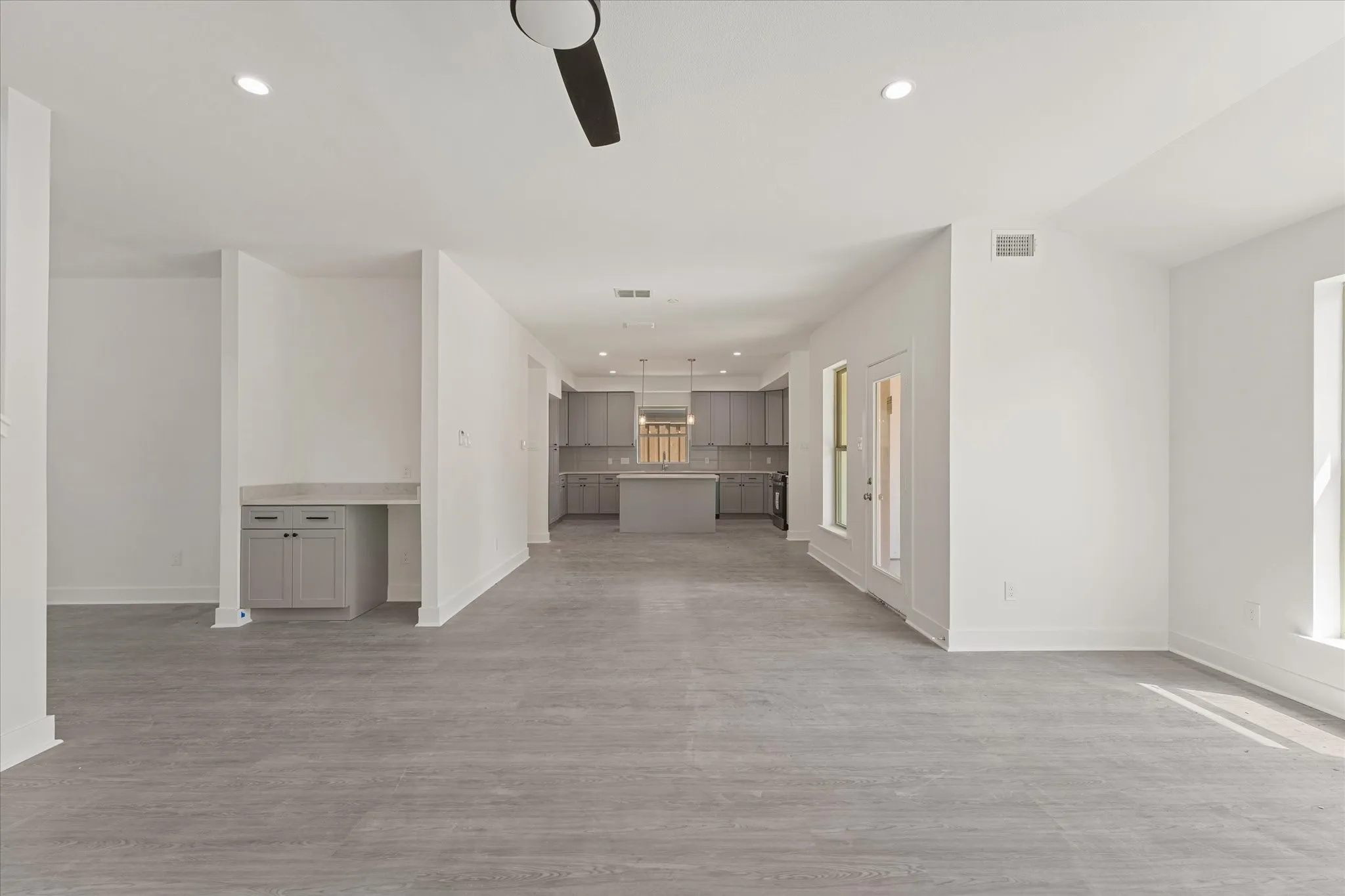 Spacious interior with wood-finish flooring, recessed lighting, and a built-in desk area