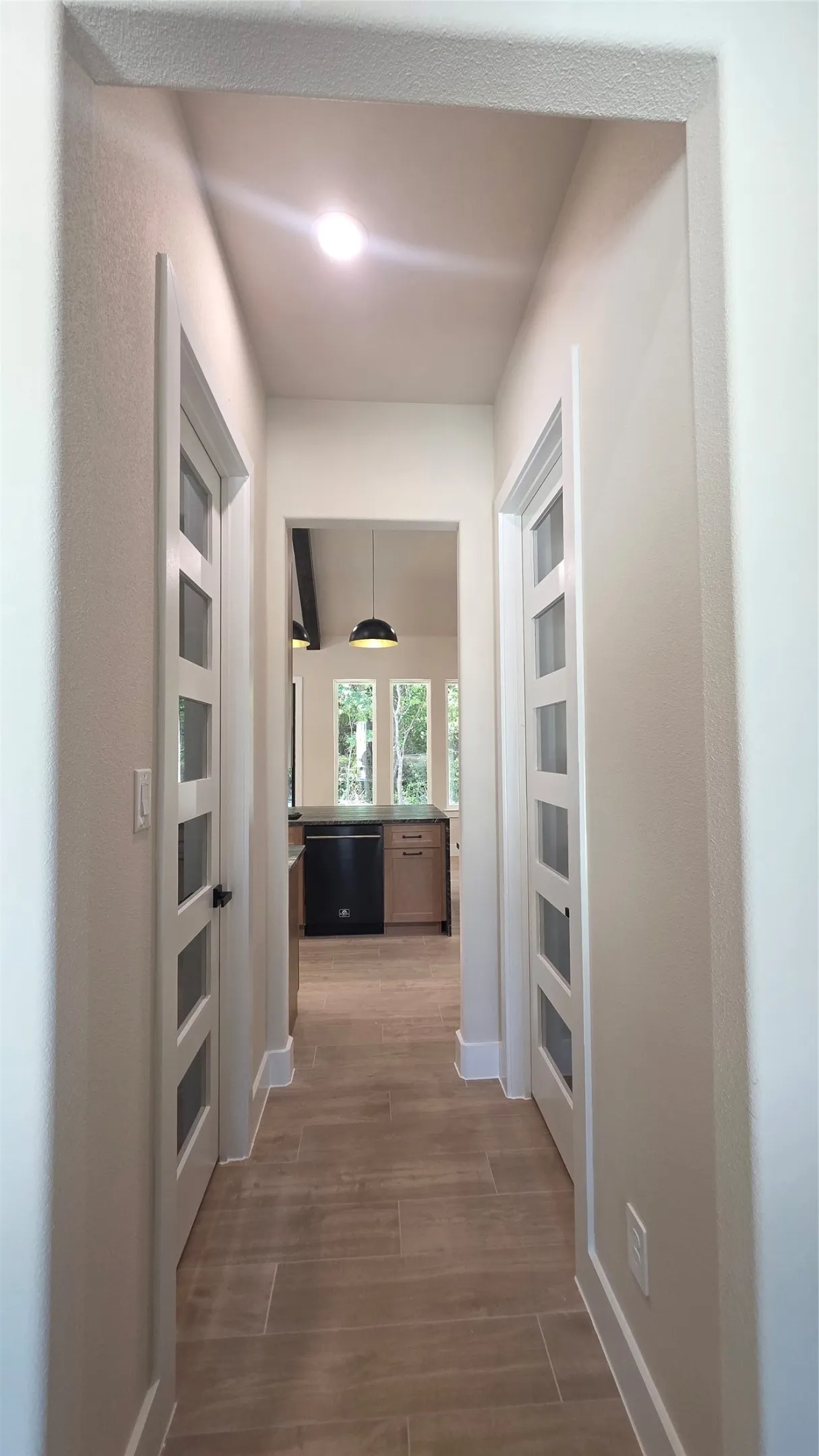 Hallway featuring recessed lighting, wood-look tile flooring, and panel doors with frosted glass inserts