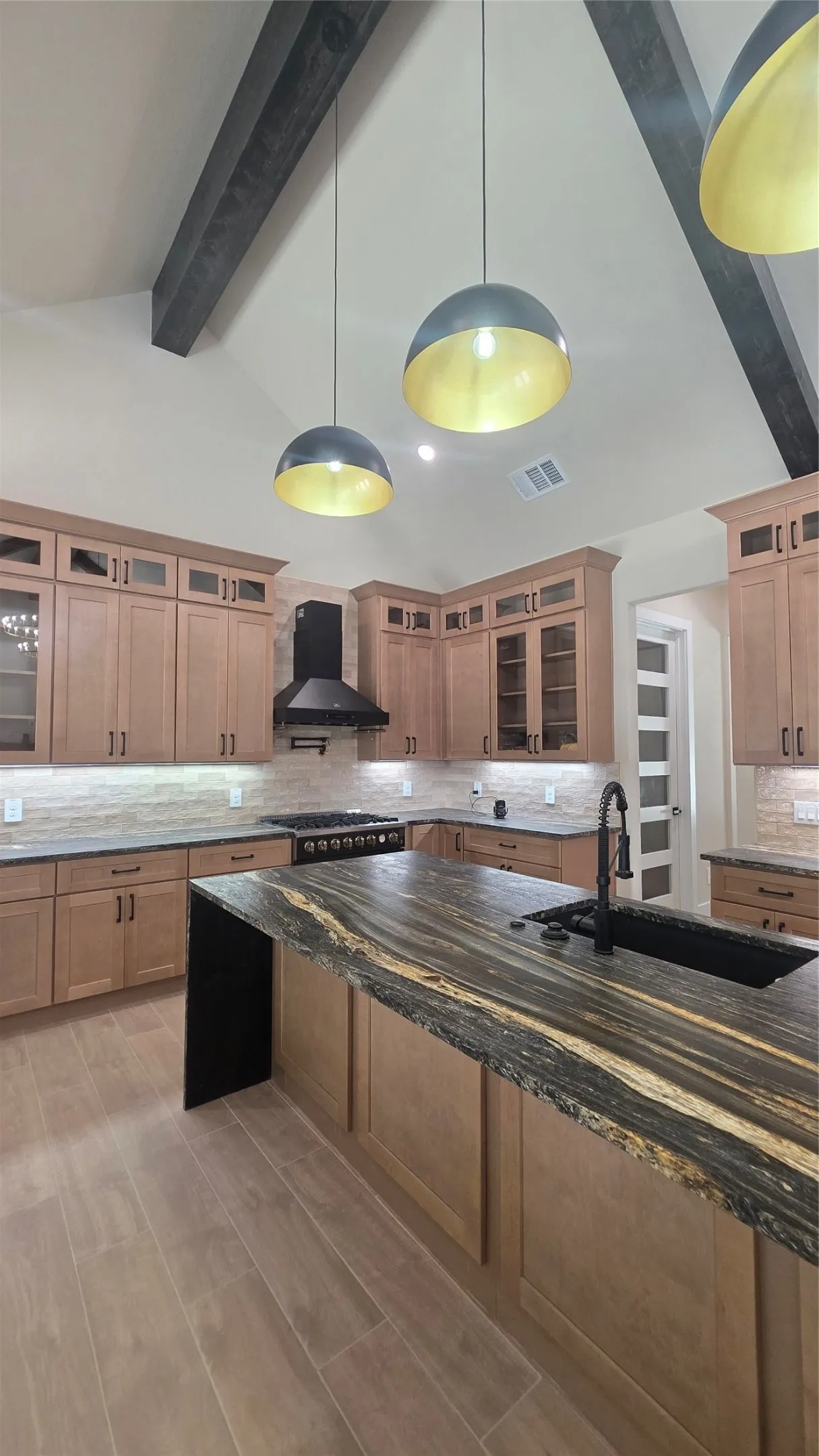 Vaulted ceiling with exposed wood beams and pendant lighting