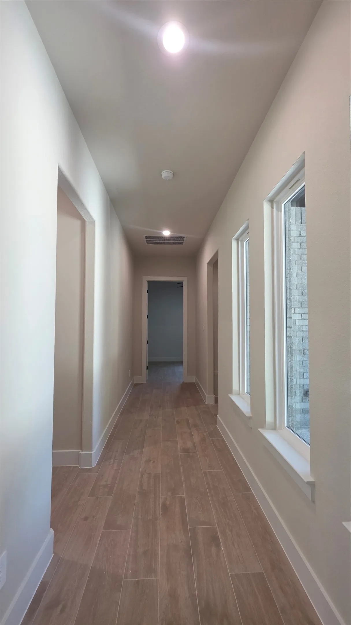 Recessed lighting illuminates the wood-finish flooring