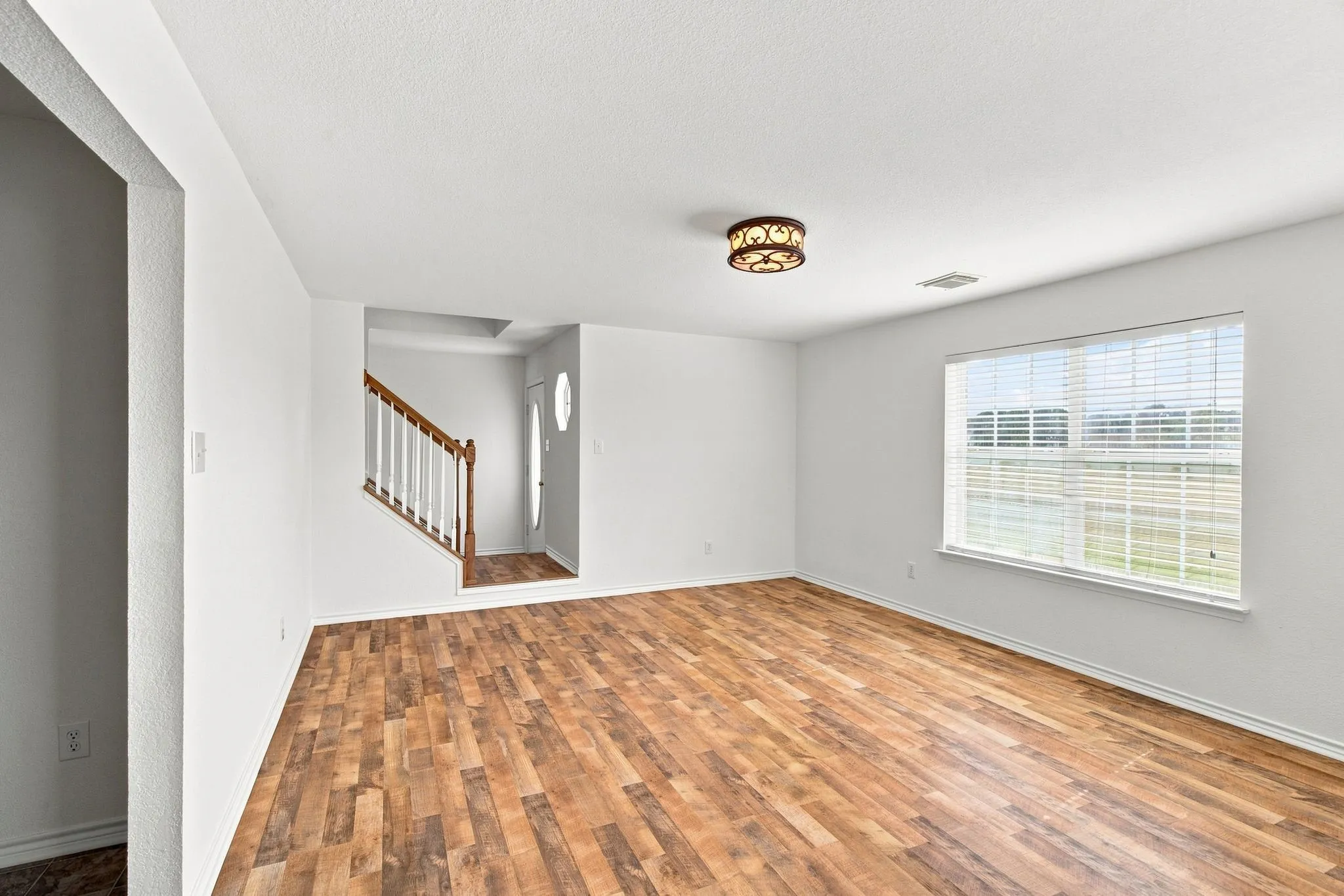 Large living area with laminate wood flooring