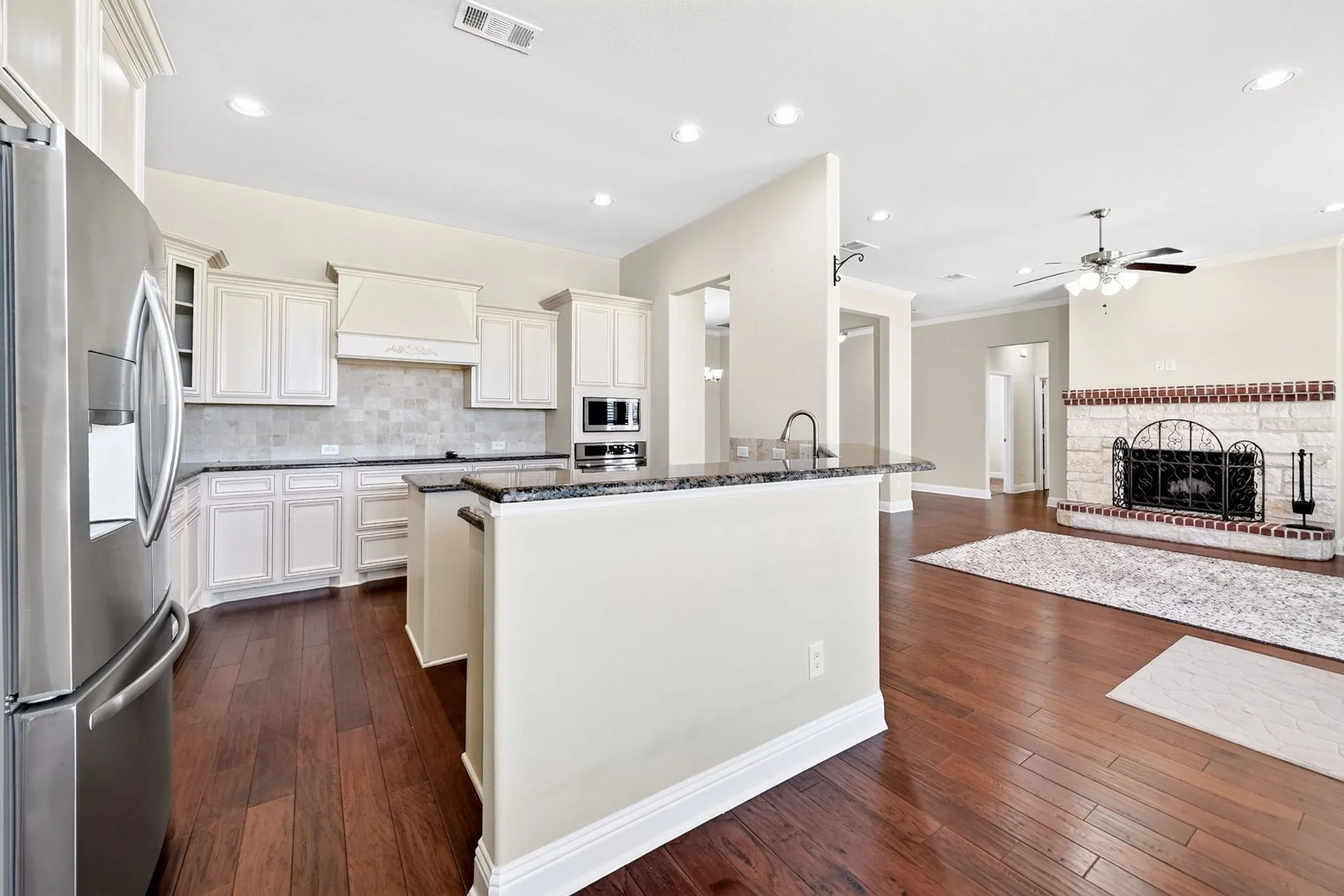 Open-concept kitchen with white cabinetry and dark countertops