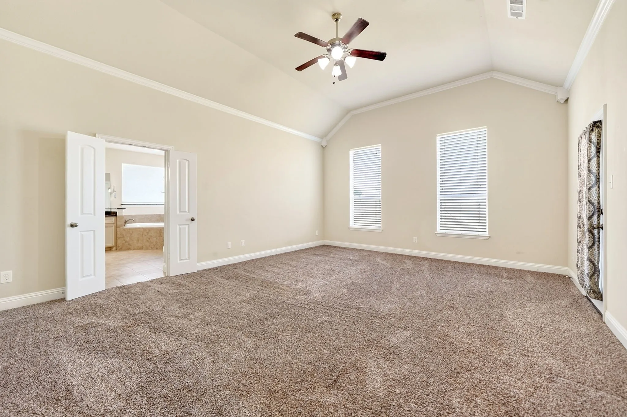Large primary bedroom with exterior door to covered back porch, rear of the home.