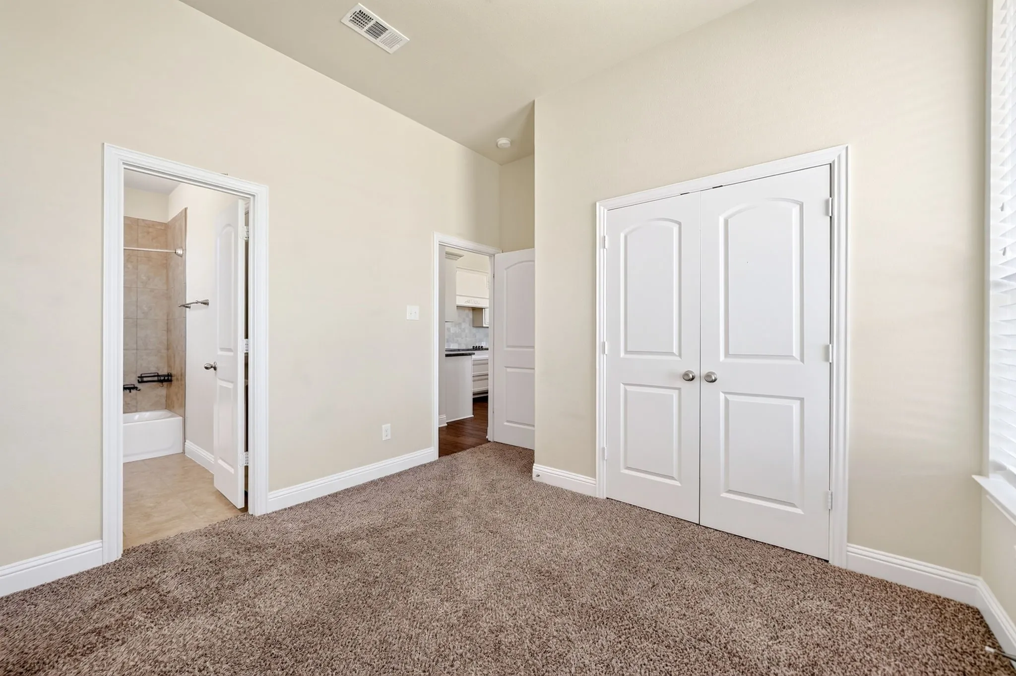 Plush carpeting, neutral wall tones, and white trim throughout plus ensuite full bathroom