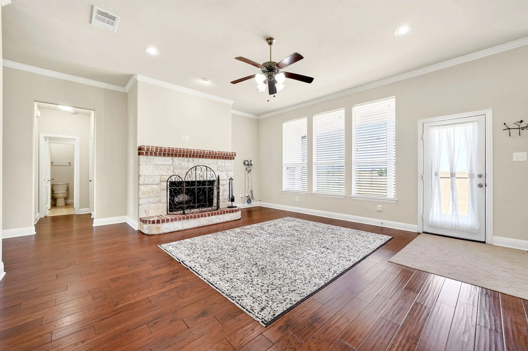 Hardwood-style flooring, a brick and stone fireplace, three large windows, a ceiling fan, and recessed lighting.  Plus Starlin Gen 3 hardware included.