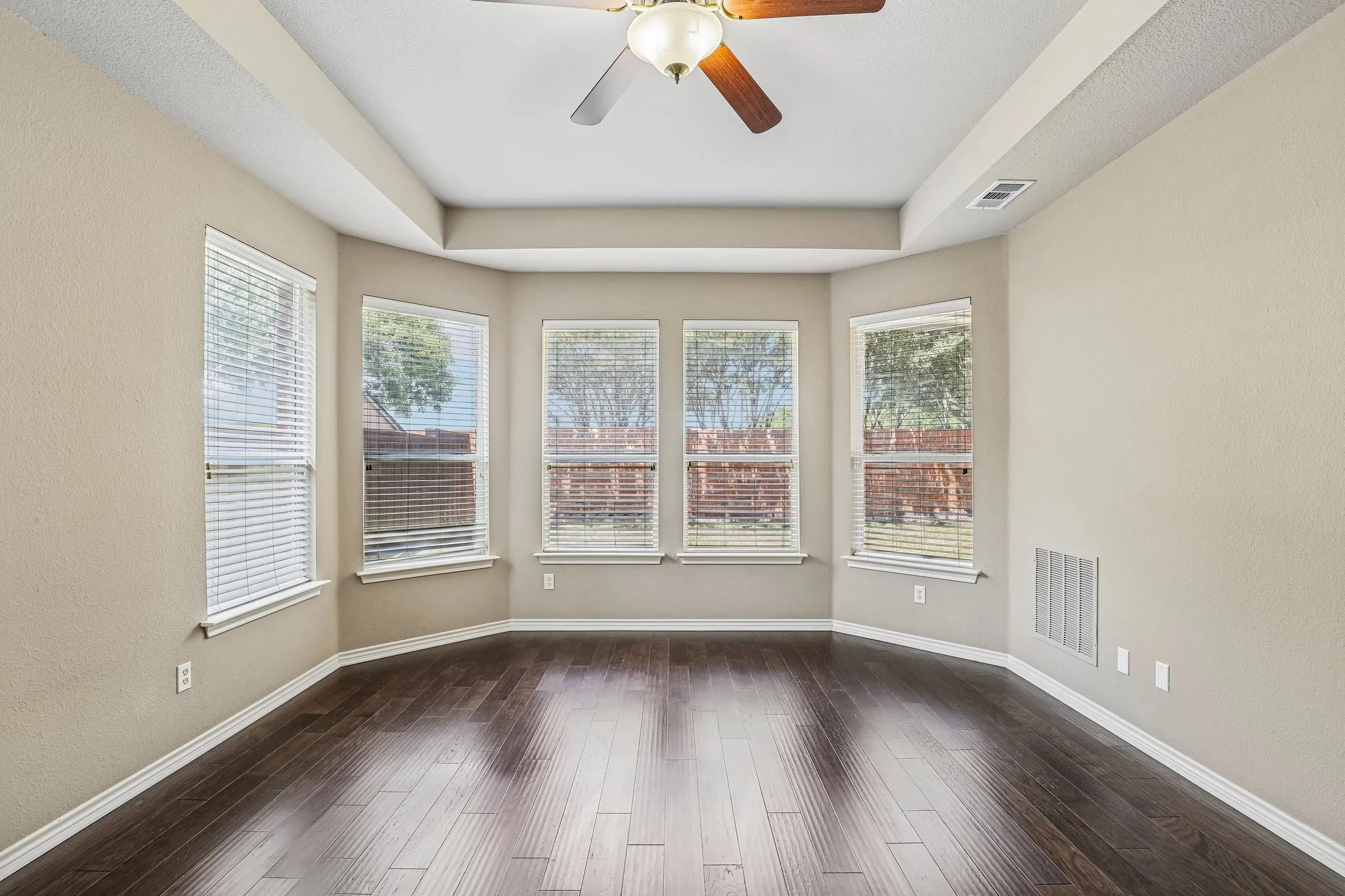Primary suite with wall of windows overlooking the backyard.