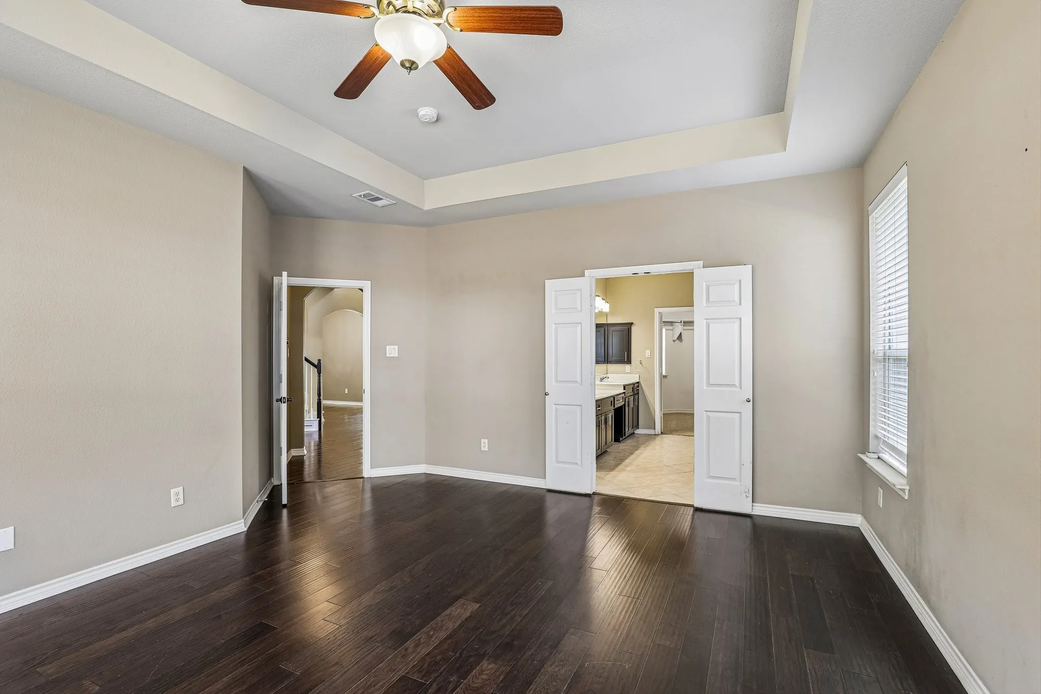 Primary suite features trey ceiling and double-door entry to en-suite bath.