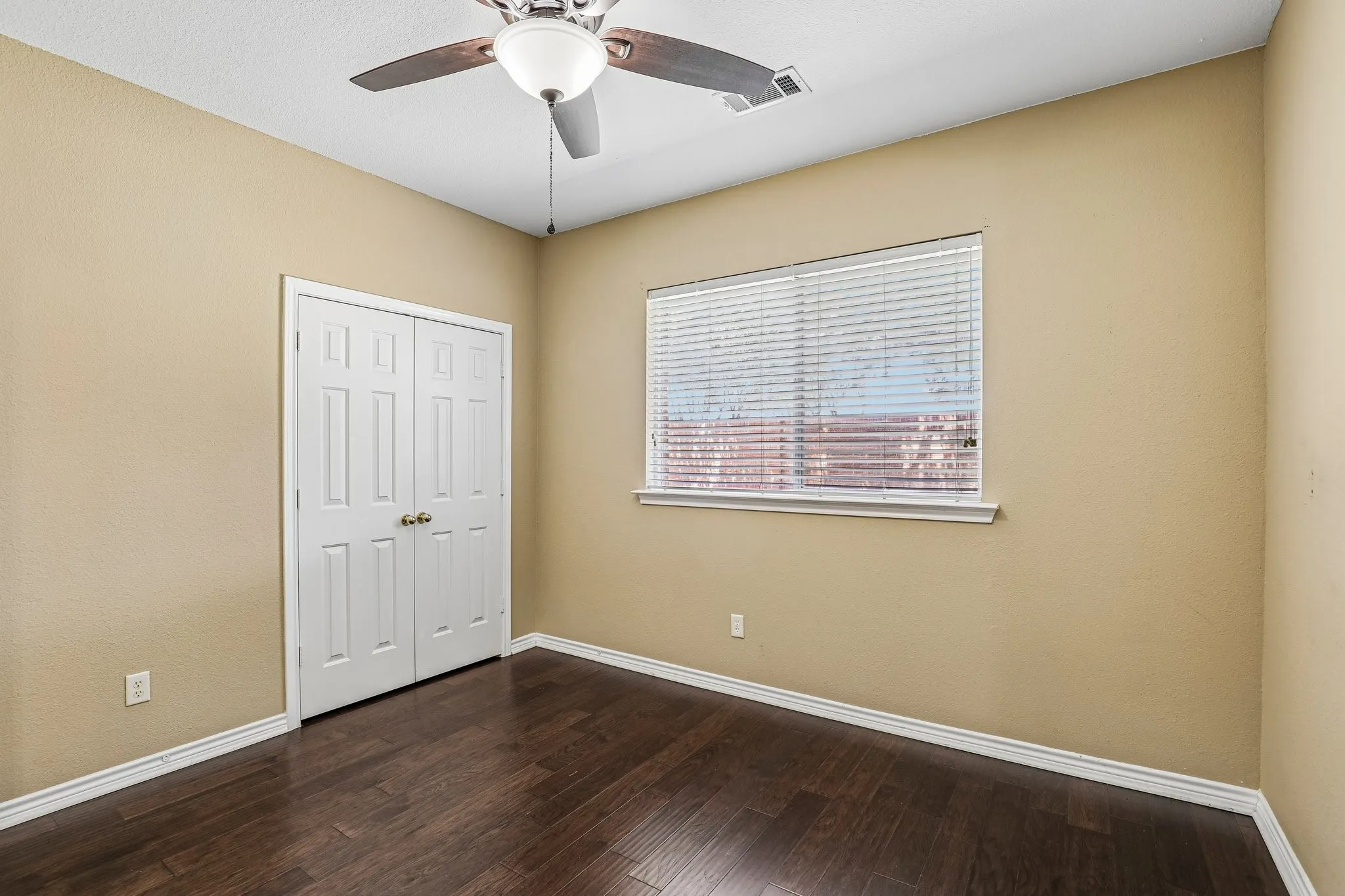 Secondary downstairs bedroom with double-door closet.