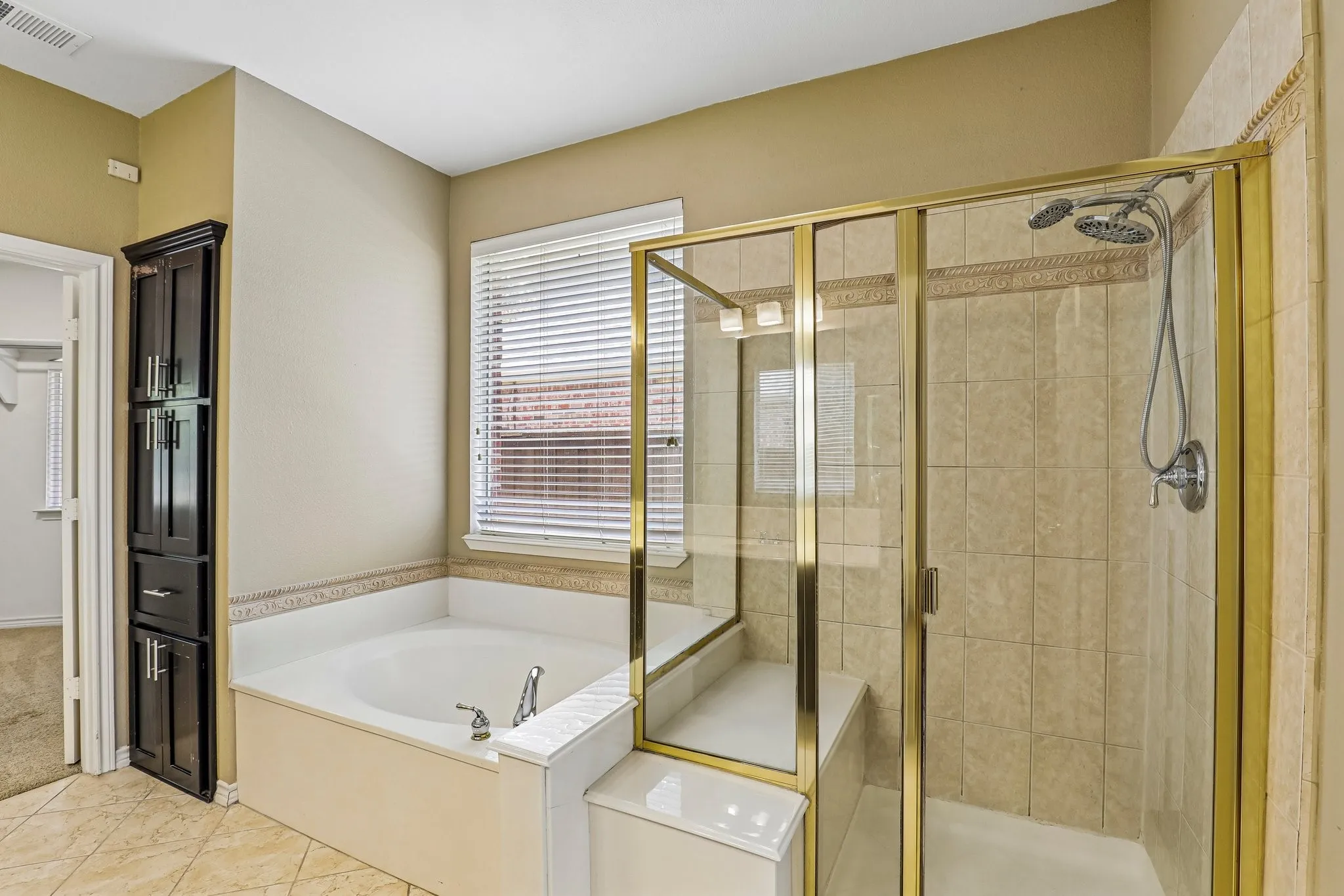 En-suite bath with soaking tub, and separate framed shower.