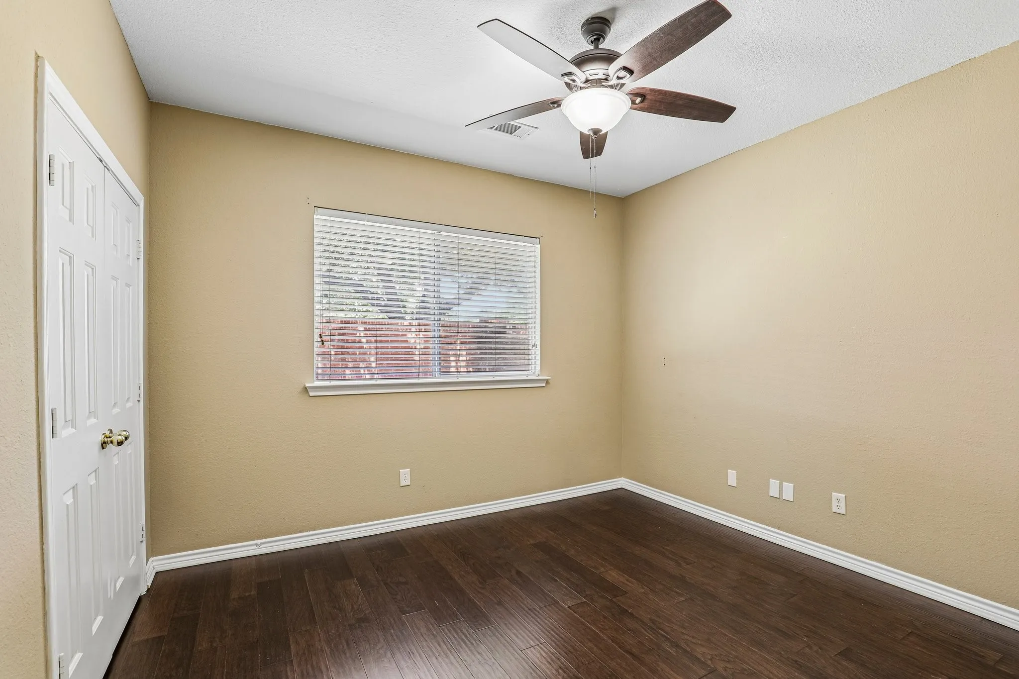 Secondary downstairs bedroom with ceiling fan.