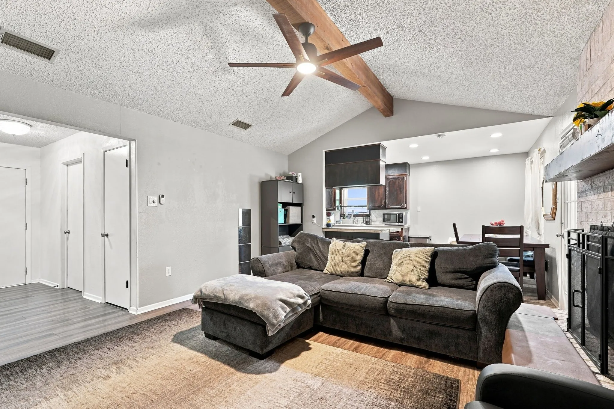 Vaulted ceiling with exposed wood beams and a ceiling fan