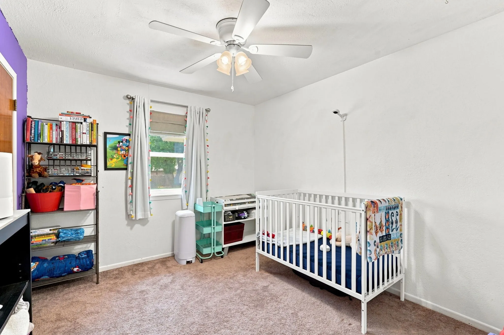 Ceiling fan with integrated lighting, carpet flooring, and window with natural light