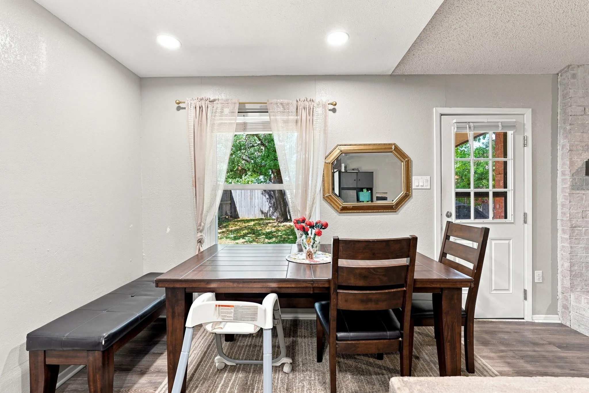 Recessed ceiling lighting, wood-finish flooring, and a white paneled door with glass inserts